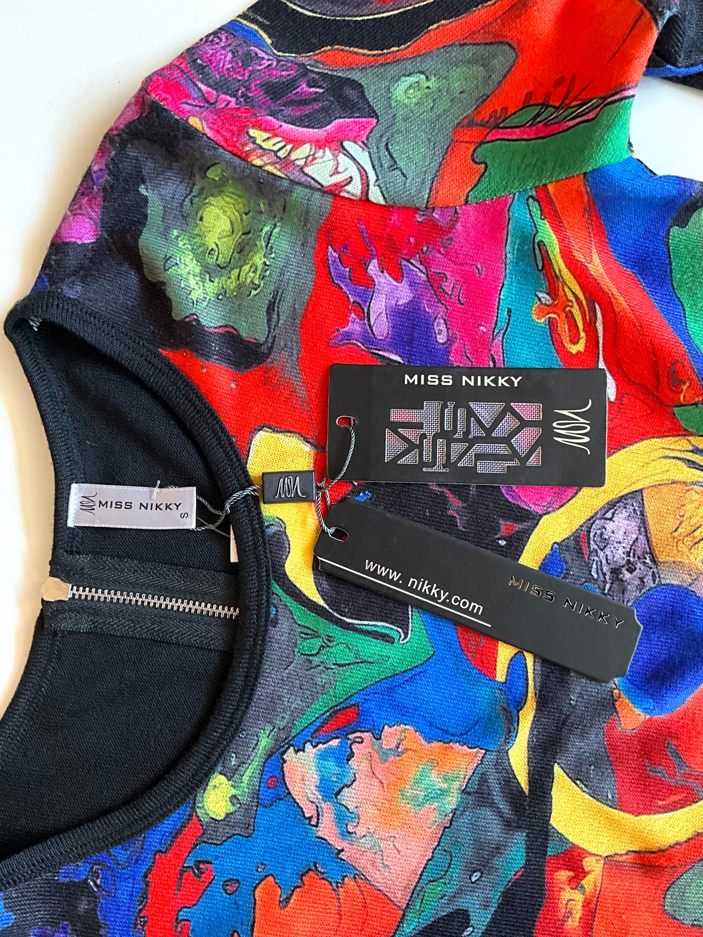 Colorful garment with 'Miss Nikky' branding on a white background