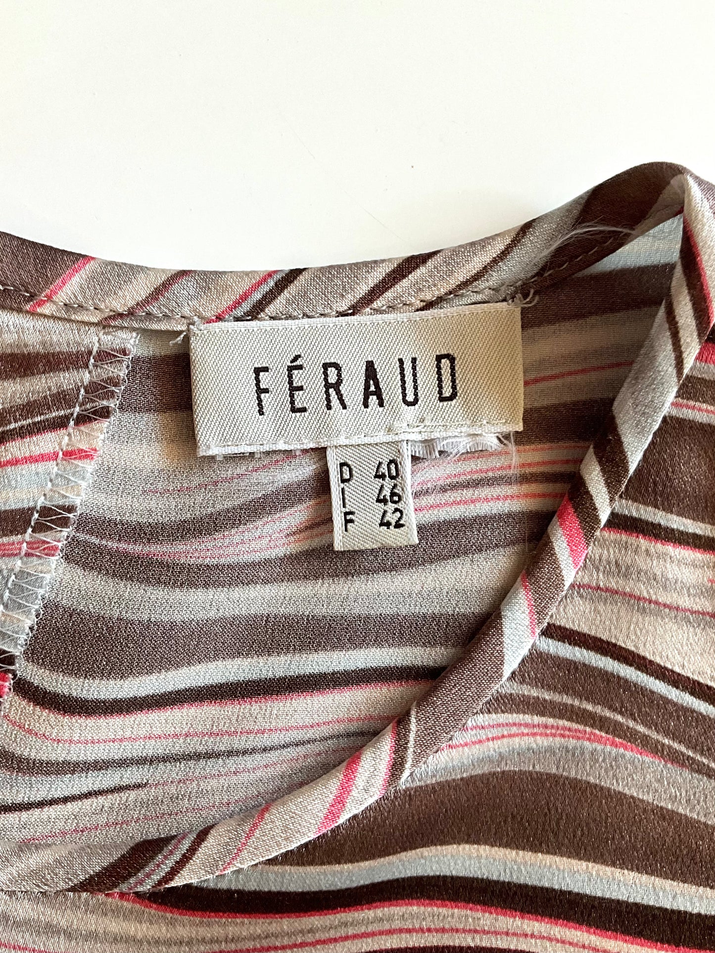 Close-up of a striped fabric with a Féraud label on a white background