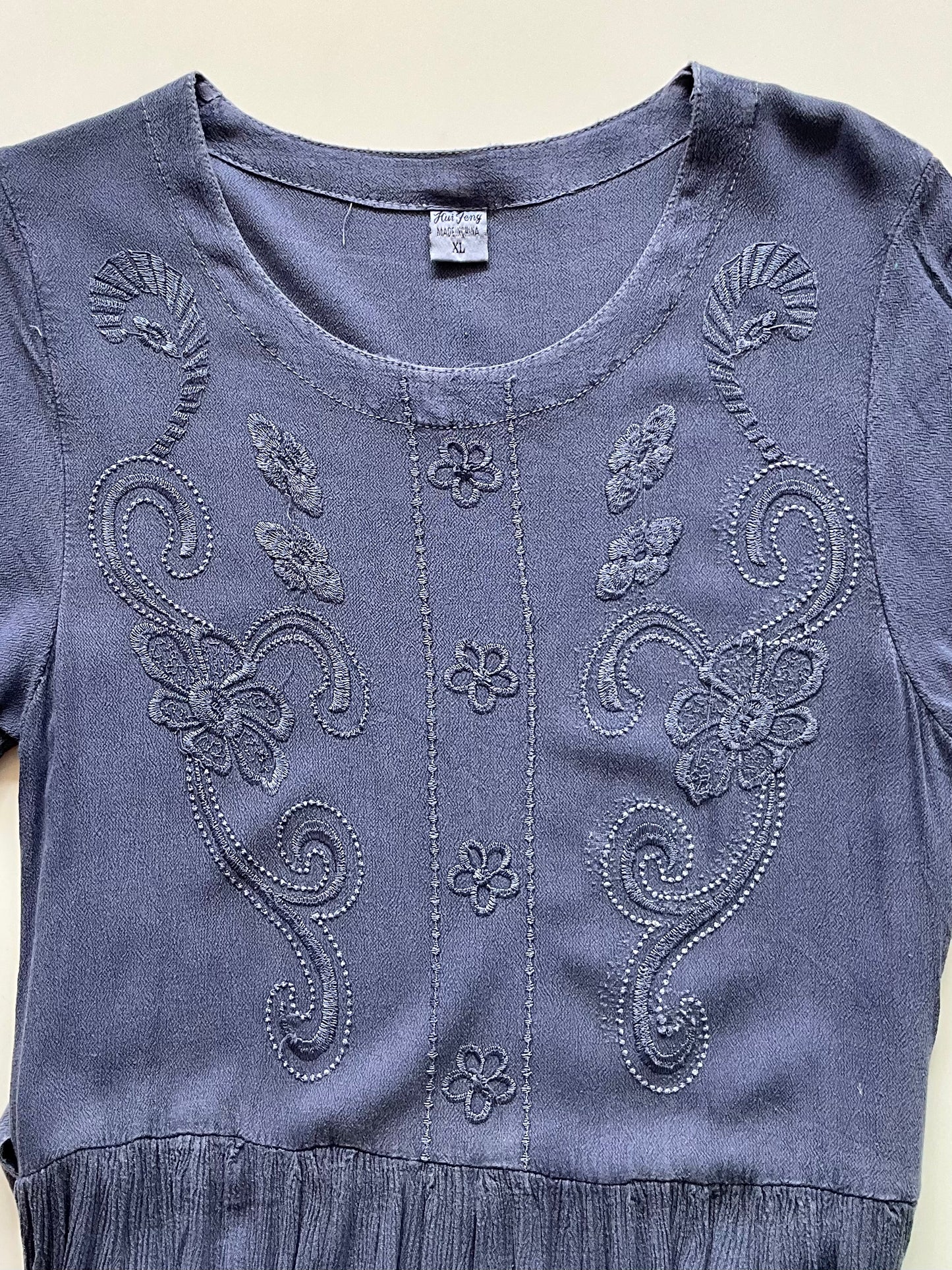 Blue dress with intricate embroidery on a white background