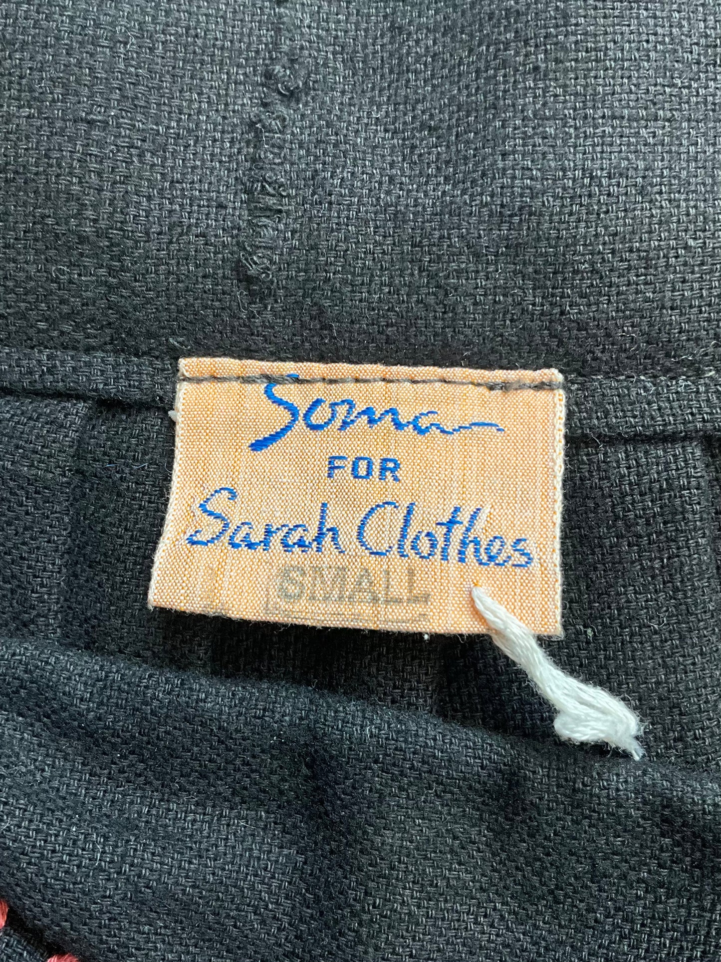 Fabric label on a black fabric with 'Soma for Sarah Clothes' text