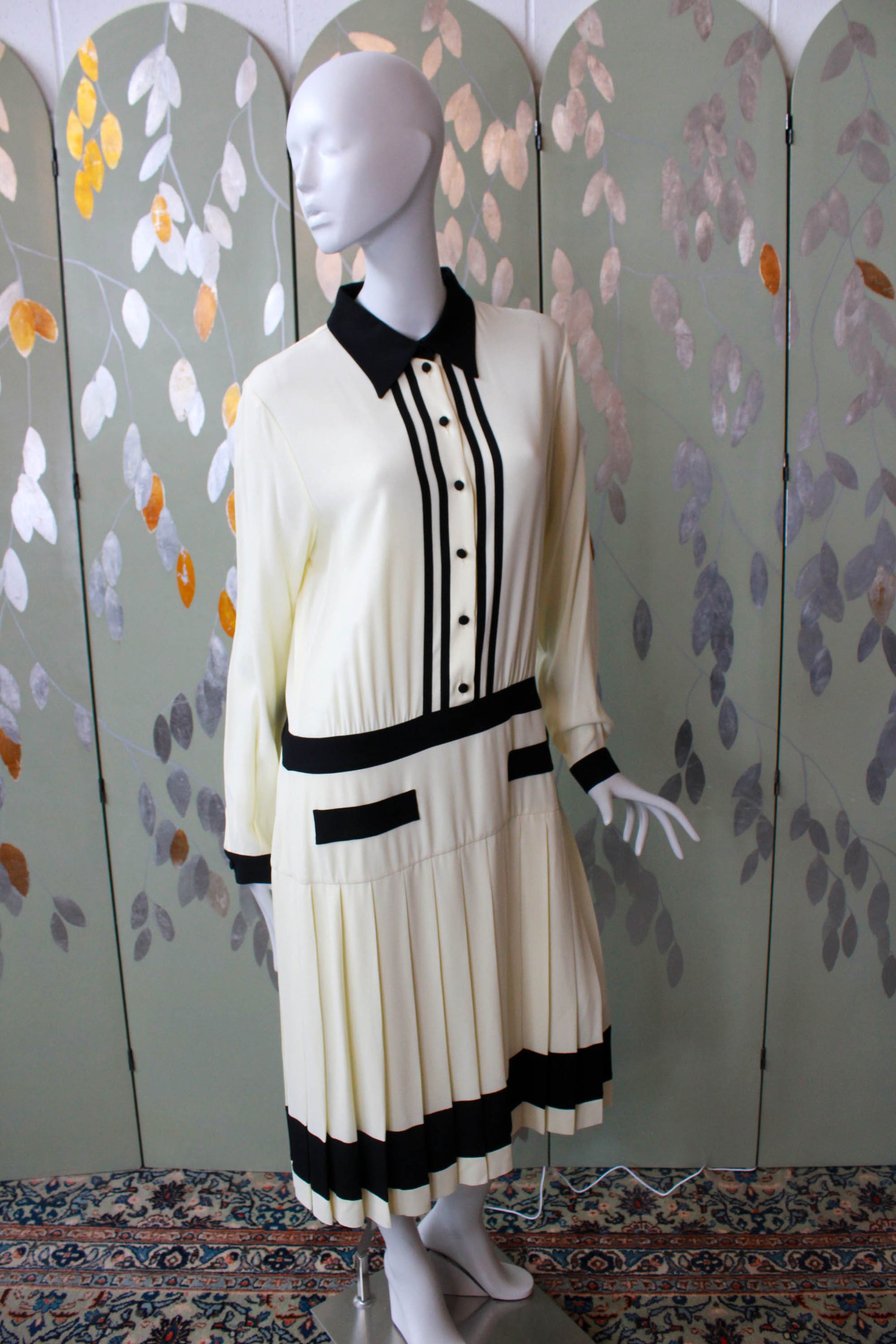 y2k Moschino 1920s style drop waist shirt dress, button up with collar, cream with black contrast bands at waist, pockets, hem, cuffs collar. Pleated skirt, faux pockets