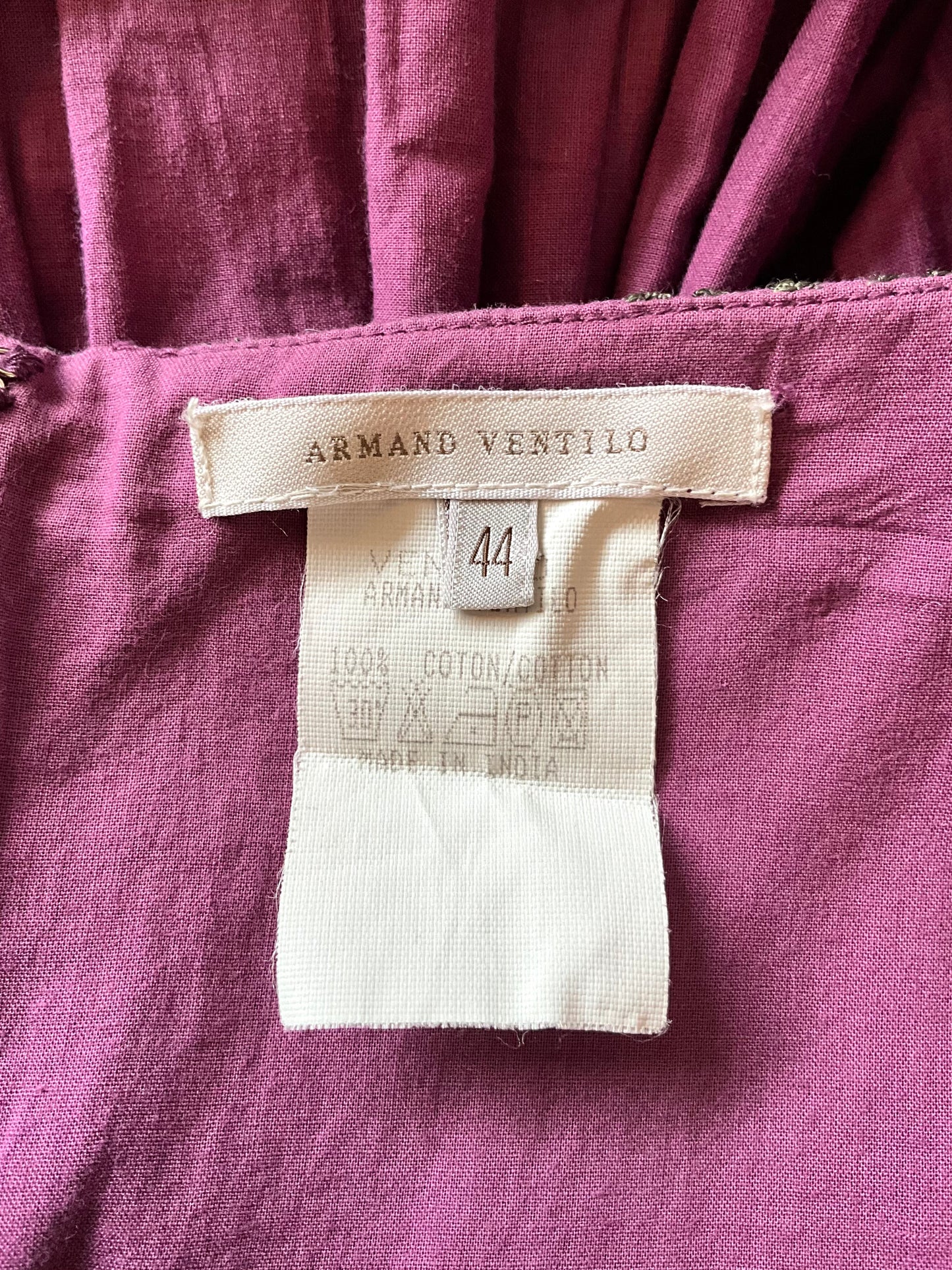 Close-up of a purple garment with an Armand Ventilo label.