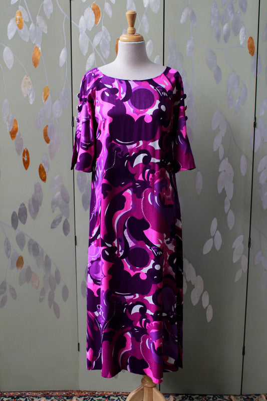 1970s purple abstract print maxi dress with flared elbow length sleeves, boat neck, buttons on sleeve