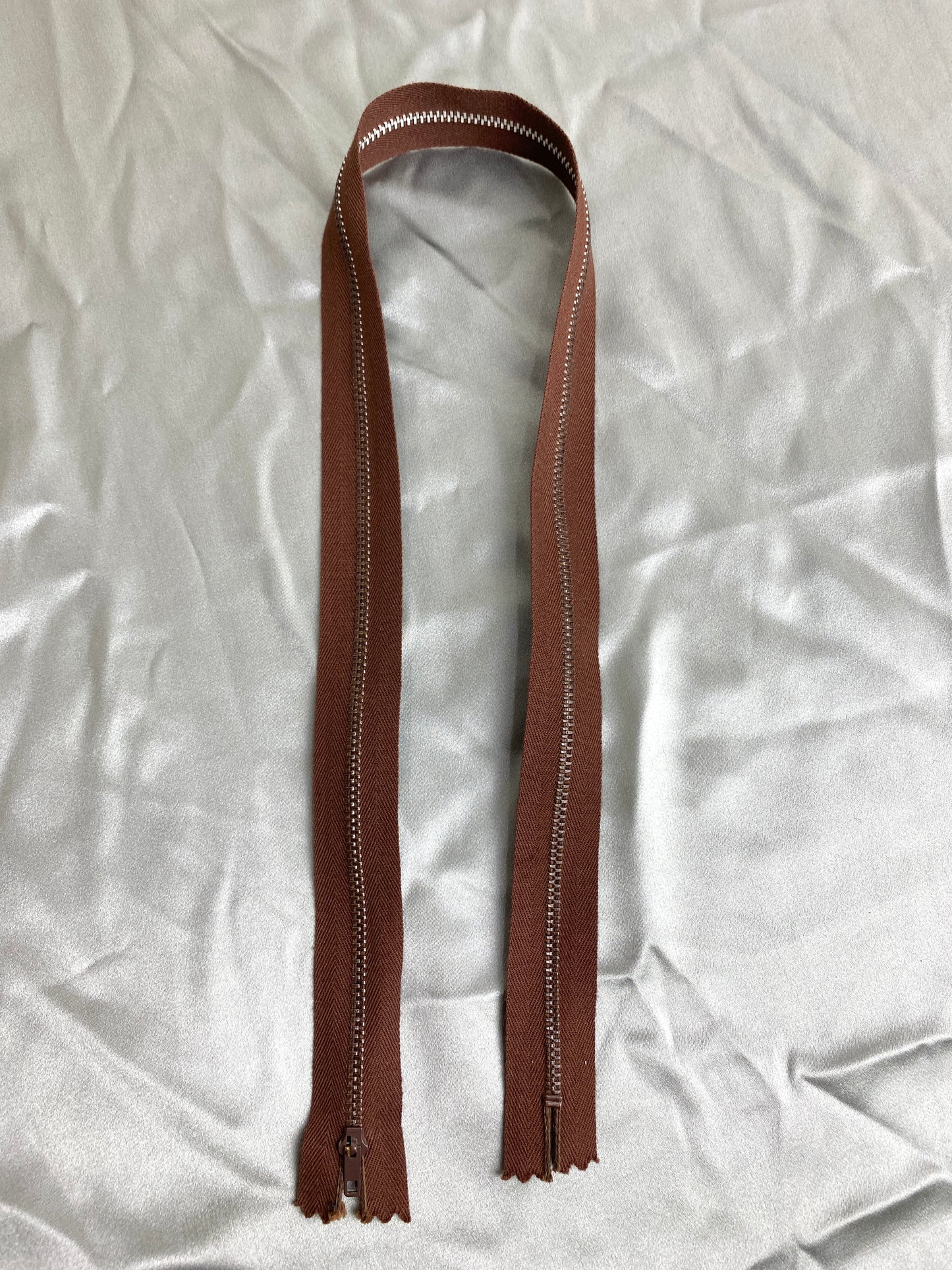 A single dark brown vintage metal zipper. Ian Drummond Vintage.
