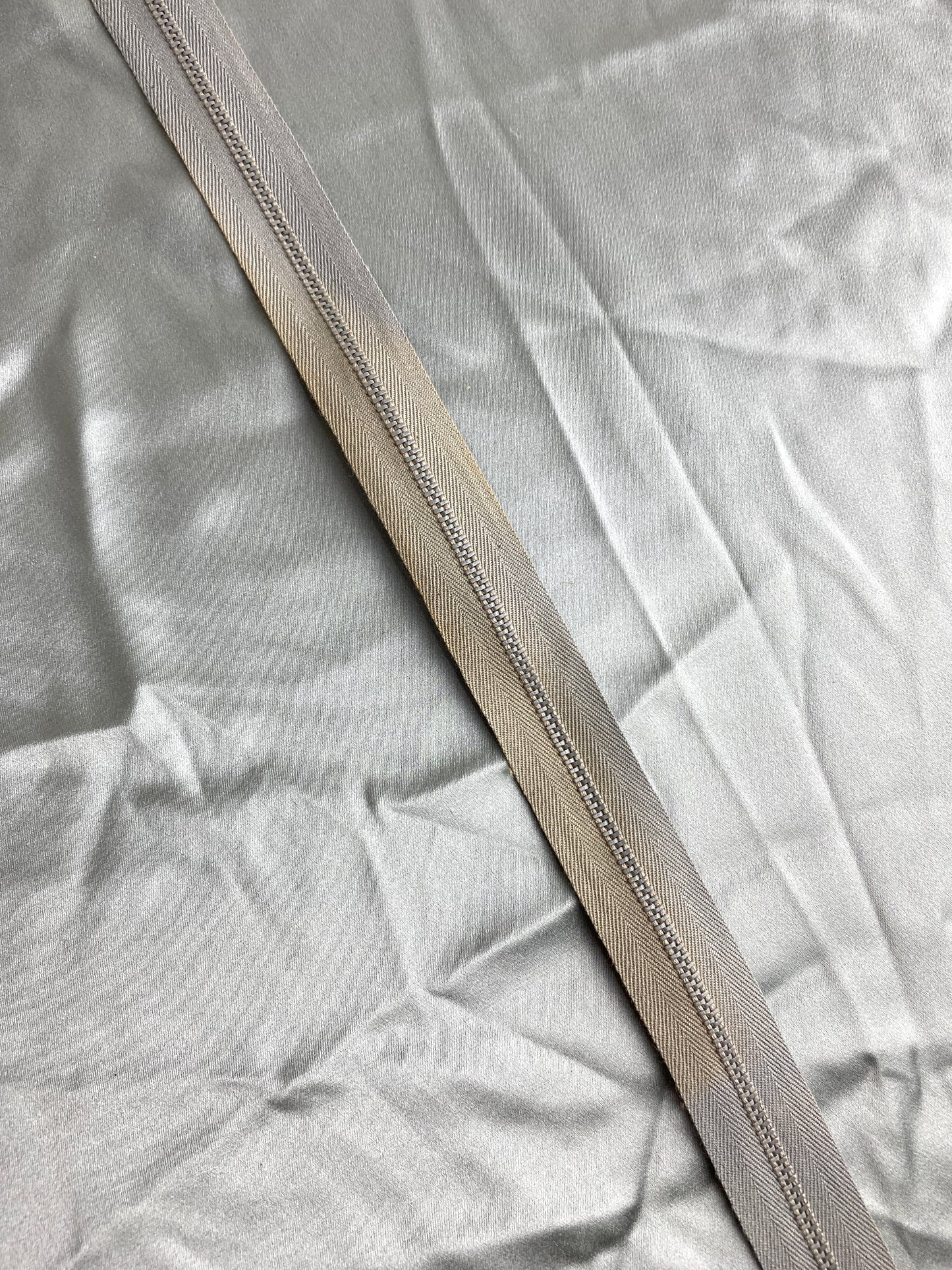 A single light grey metal zipper. Ian Drummond Vintage.