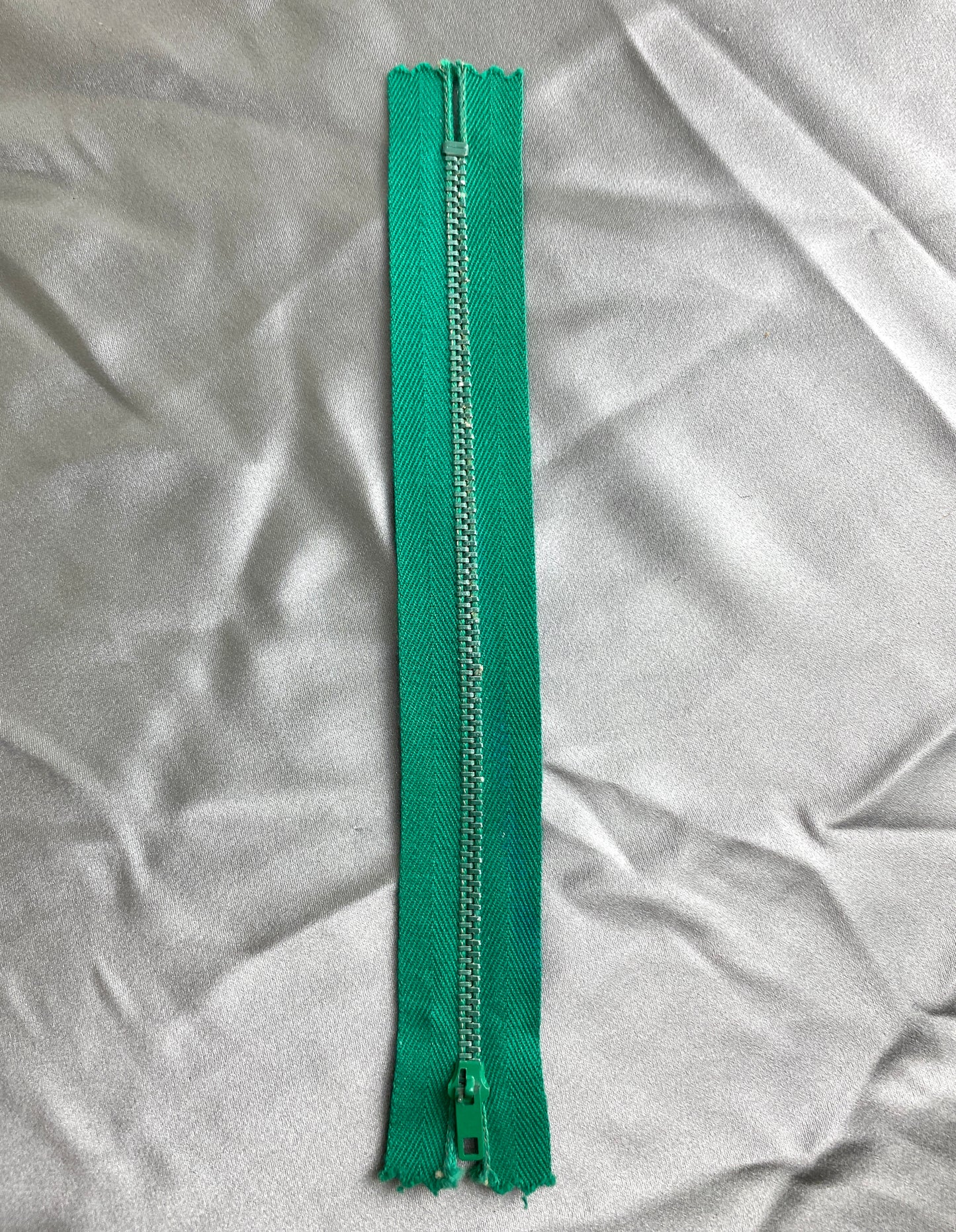A single deep green metal vintage zipper. Ian Drummond Vintage.