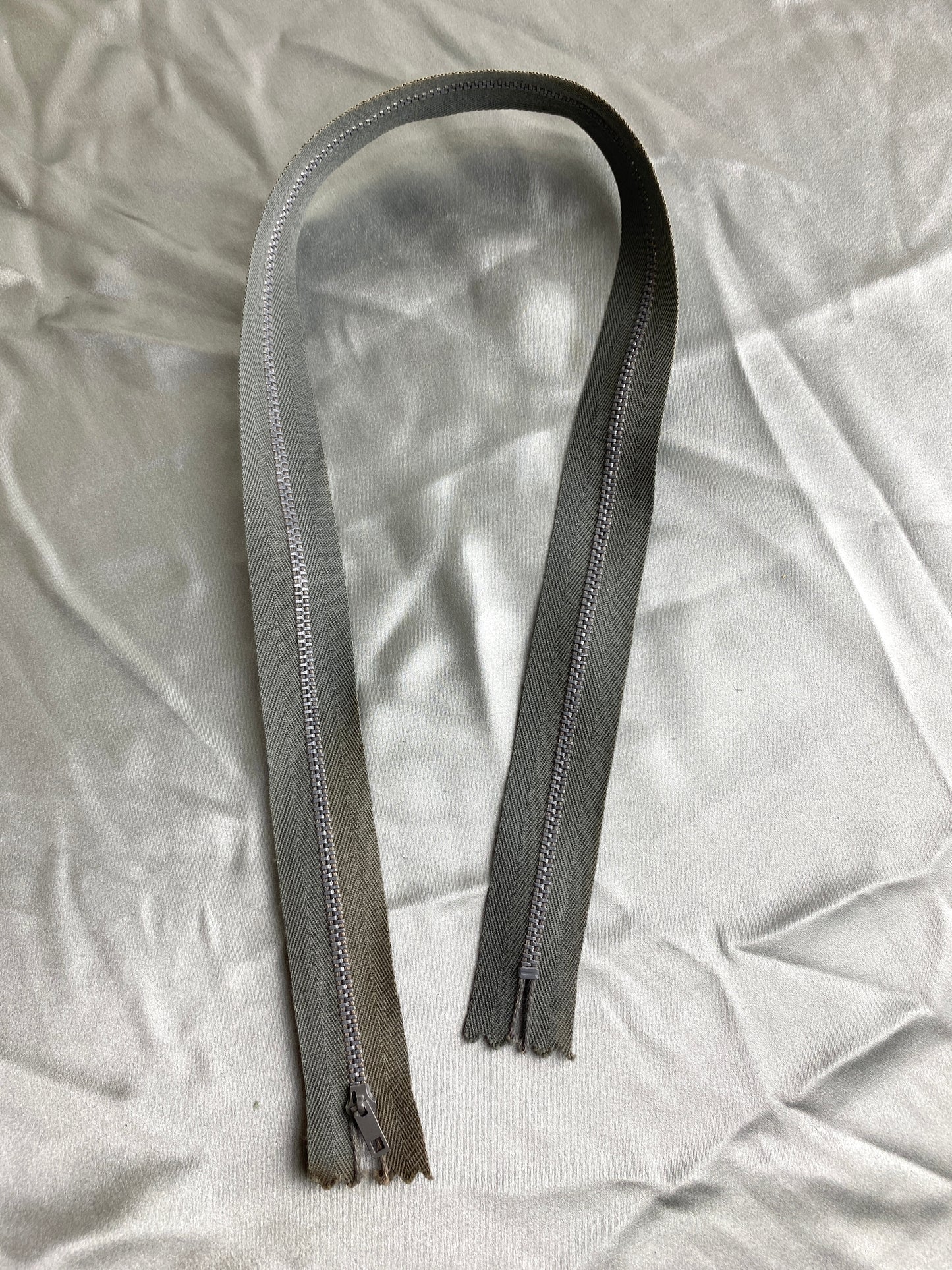 A single dark grey metal zipper. Ian Drummond Vintage.