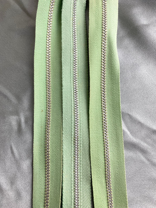 A batch of light green metal zippers. Ian Drummond Vintage. 