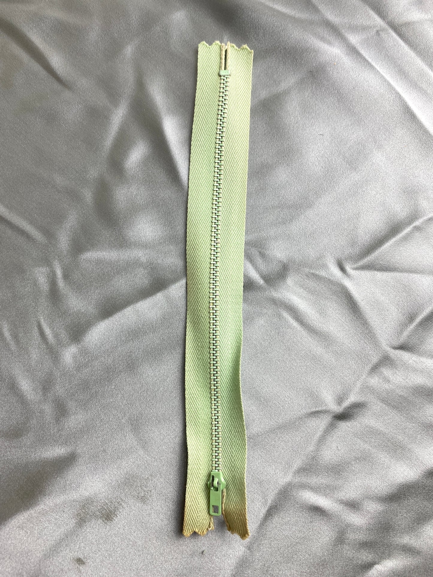 A single light green metal zipper. Ian Drummond Vintage.