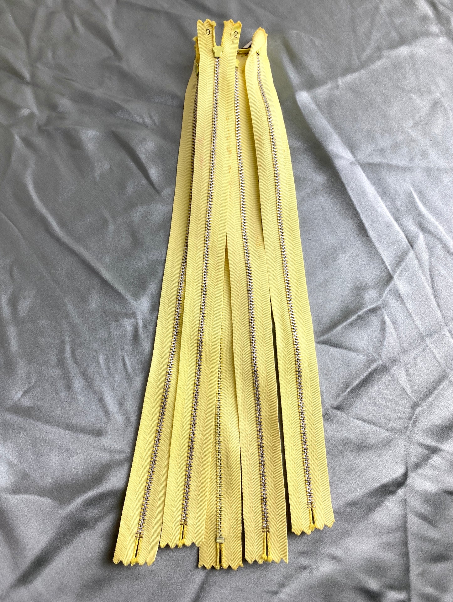 A batch of light yellow metal zippers. Ian Drummond Vintage.