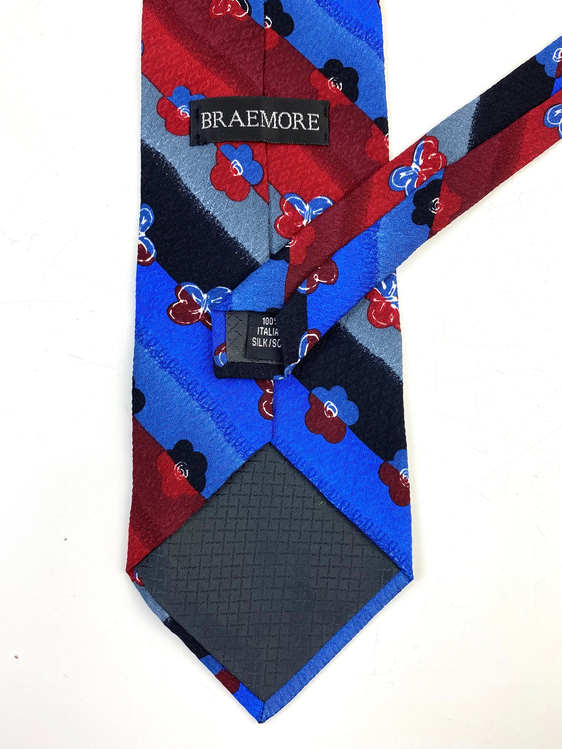 Back and labels of: 90s Deadstock Silk Necktie, Men's Vintage Wine/ Blue/ Black Floral Diagonal Stripe Pattern Tie, NOS