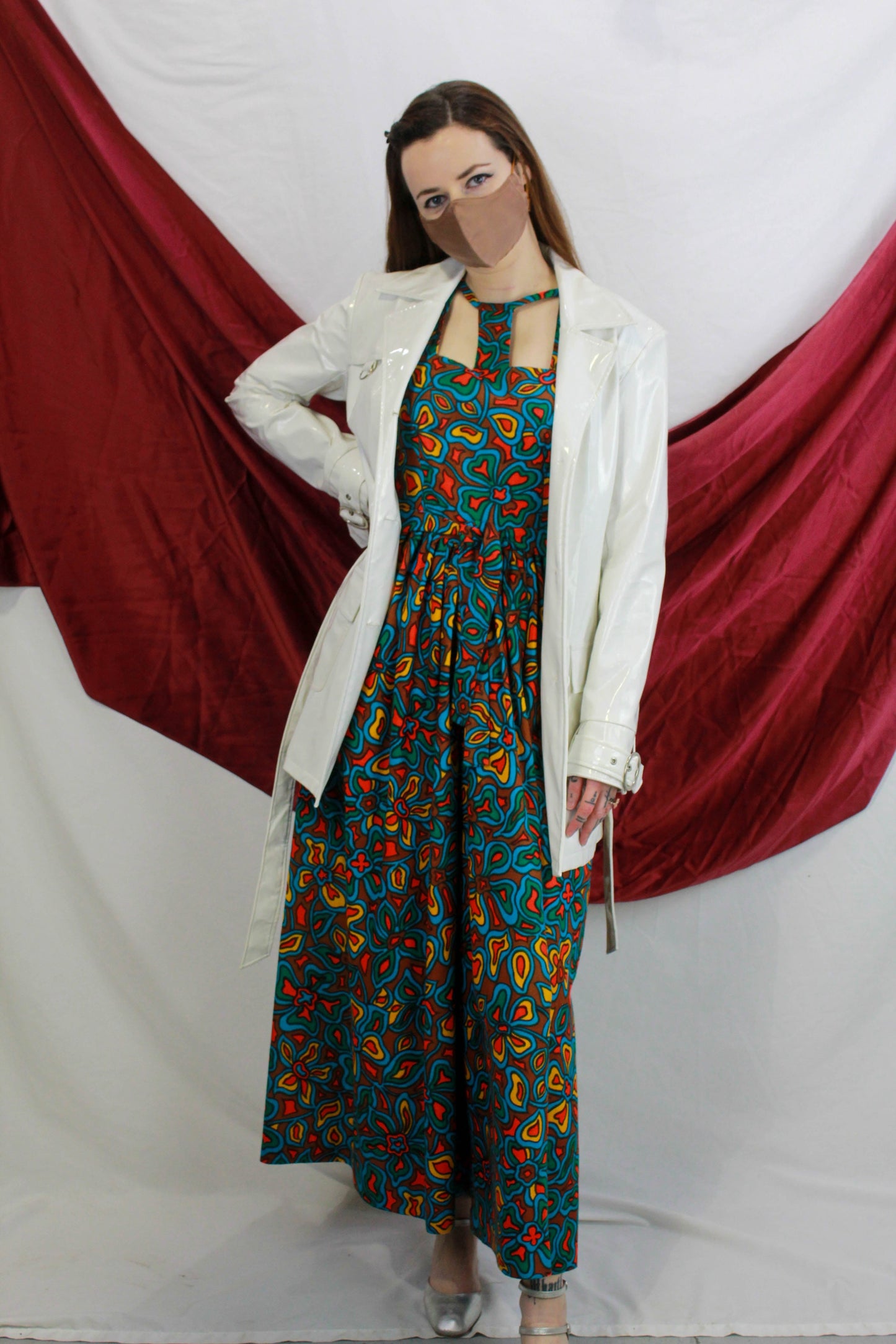 vintage 70s psychedelic print palazzo jumpsuit worn with white coat. Ian Drummond Vintage. 