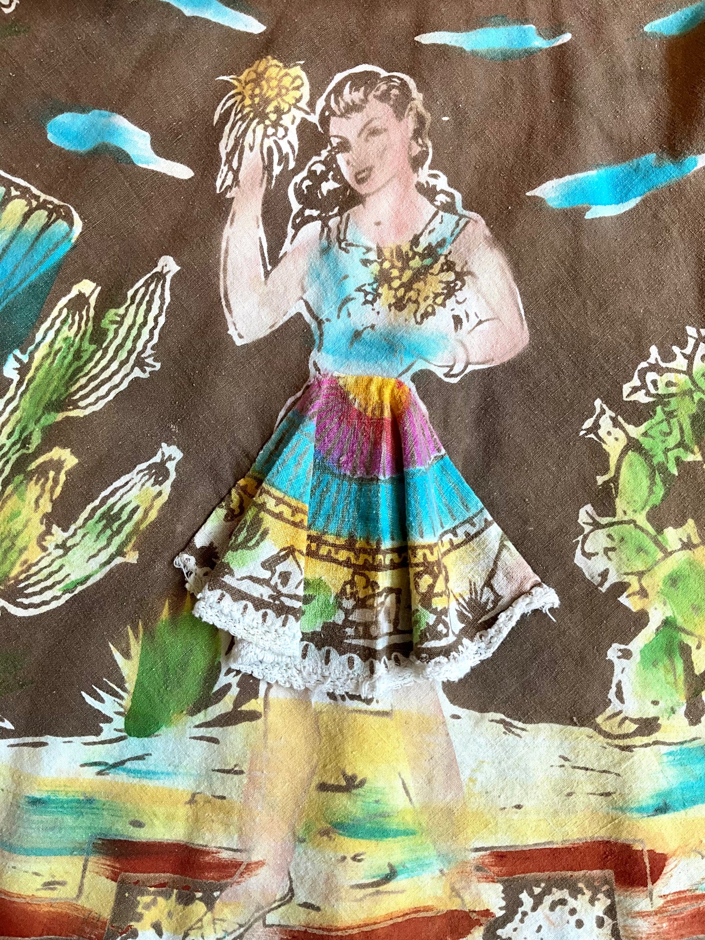 Vintage-style fabric with a woman in a colorful dress and cacti design.