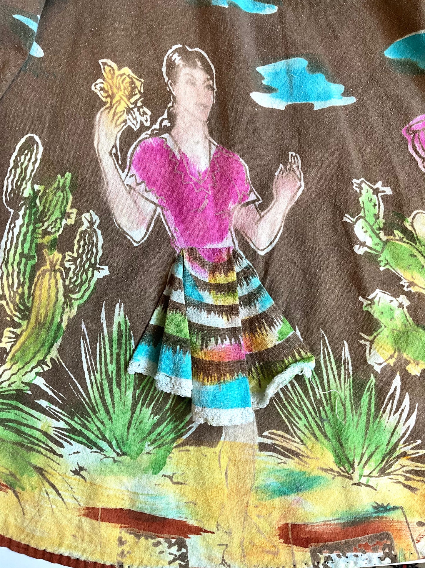 Colorful patterned fabric with a person and desert scene design.
