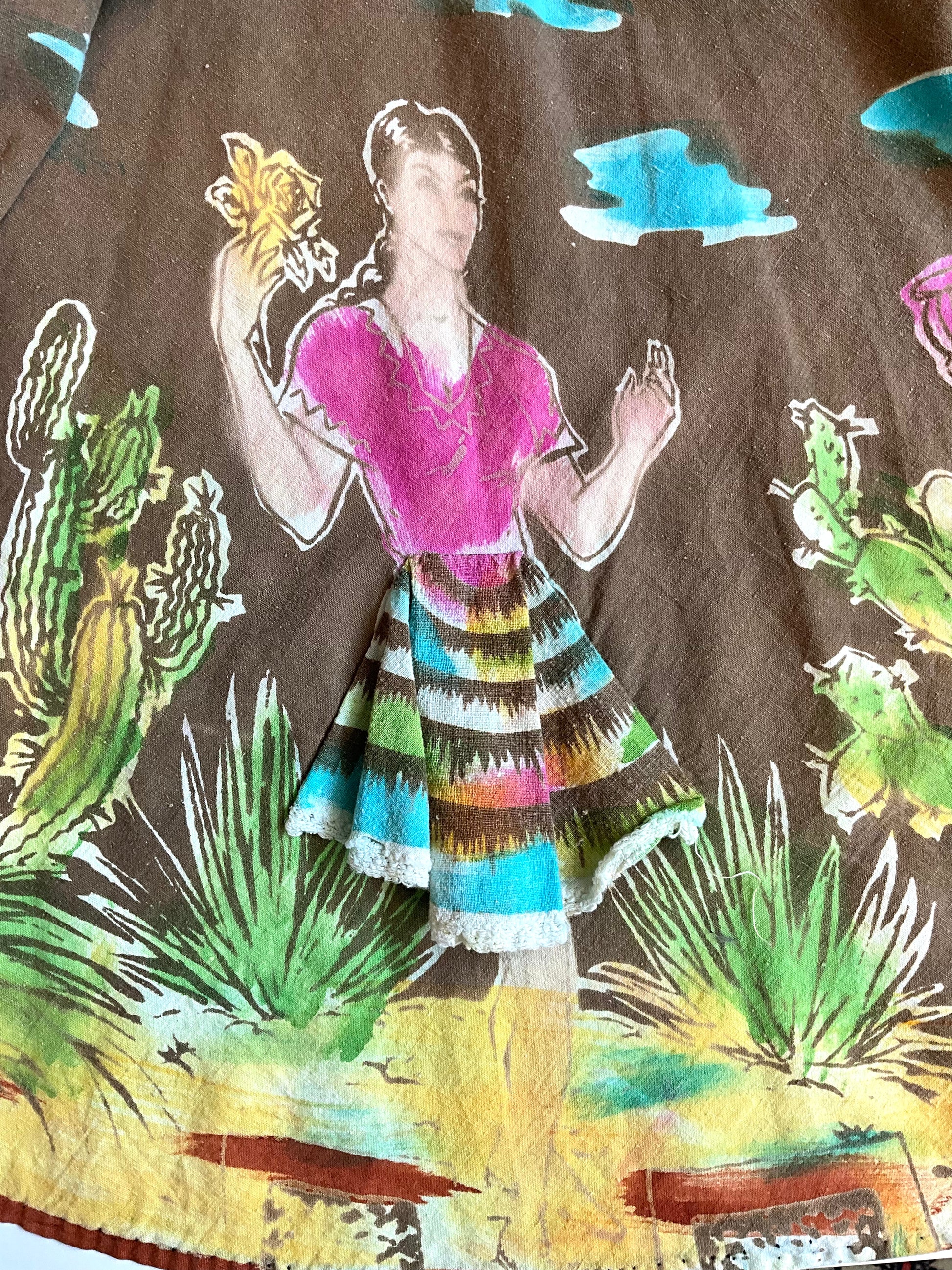 Colorful patterned fabric with a person and desert scene design.
