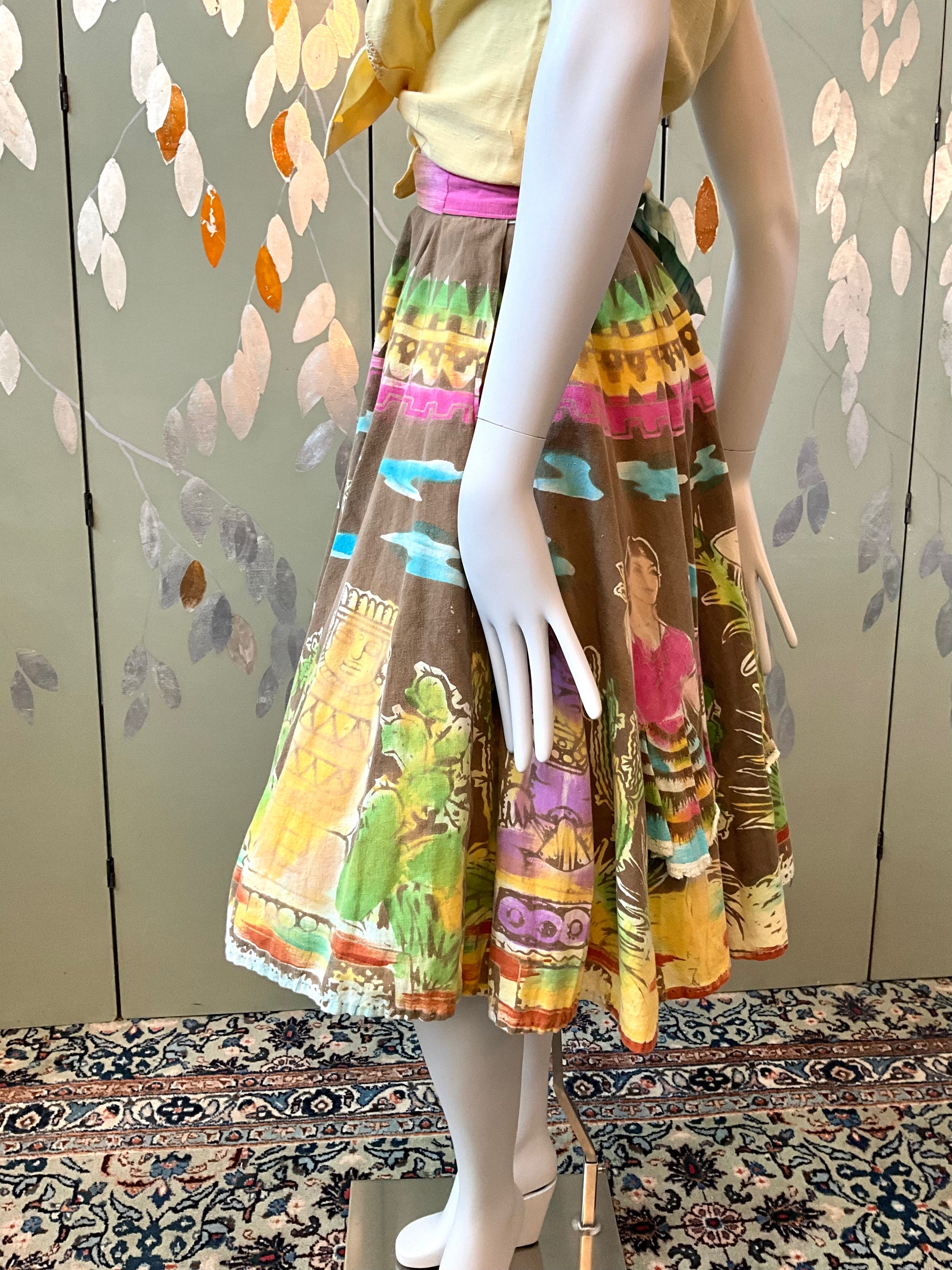 Mannequin wearing a colorful skirt with a pattern on a patterned floor.