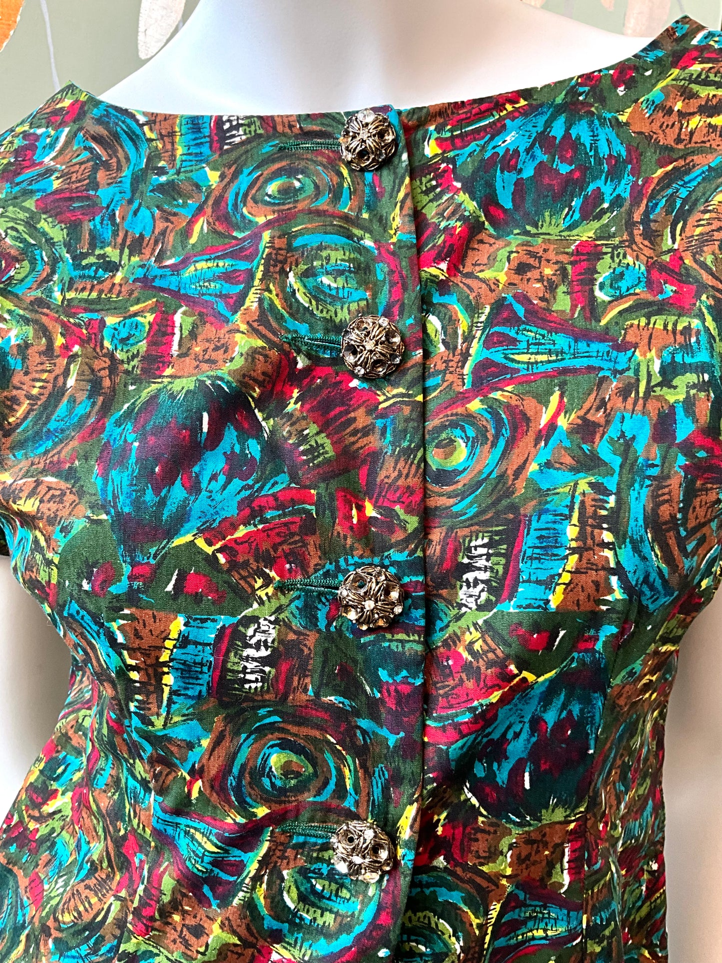 Colorful patterned garment on a mannequin with a white background