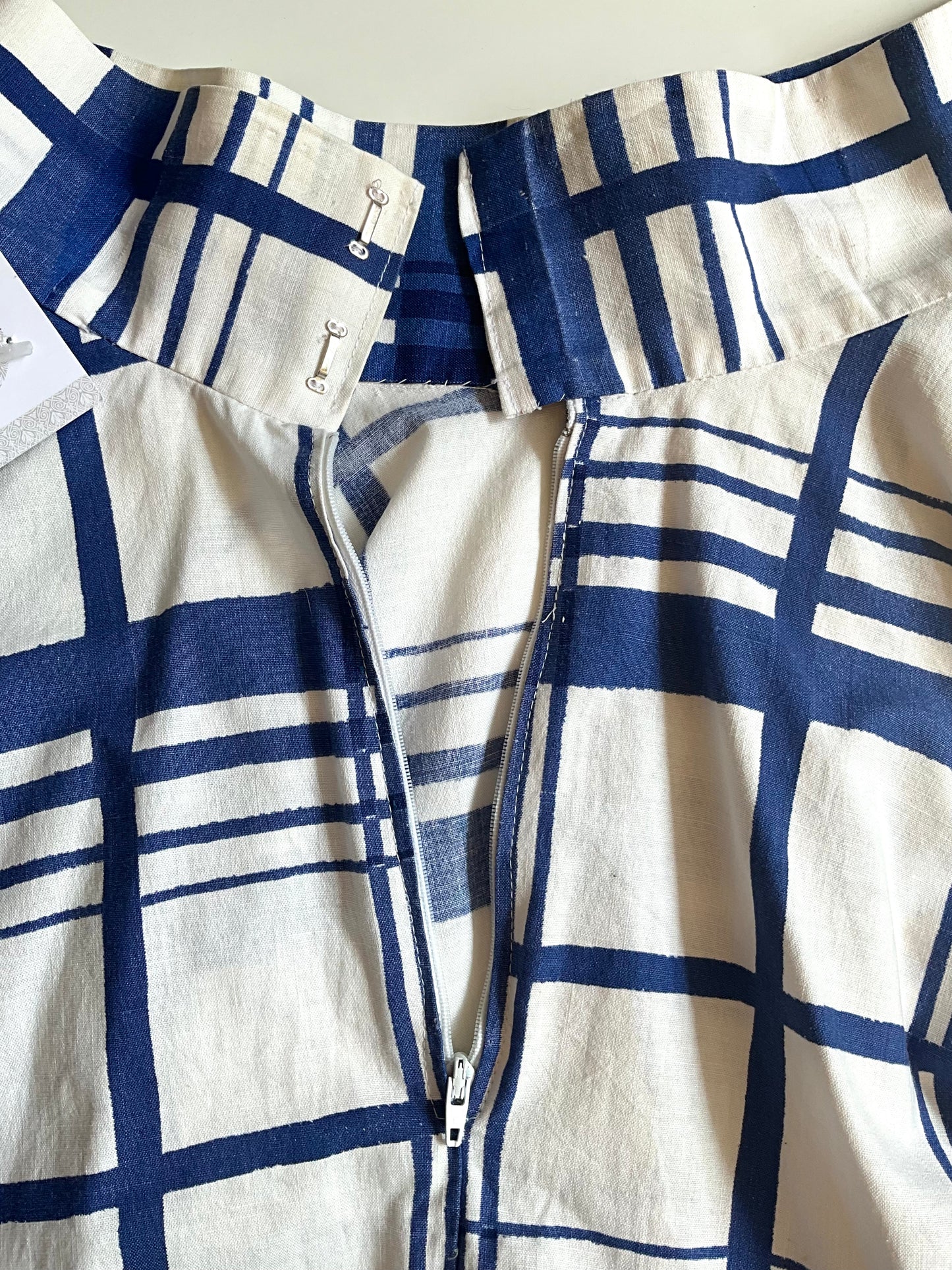 Close-up of a blue and white checkered shirt with a zipper