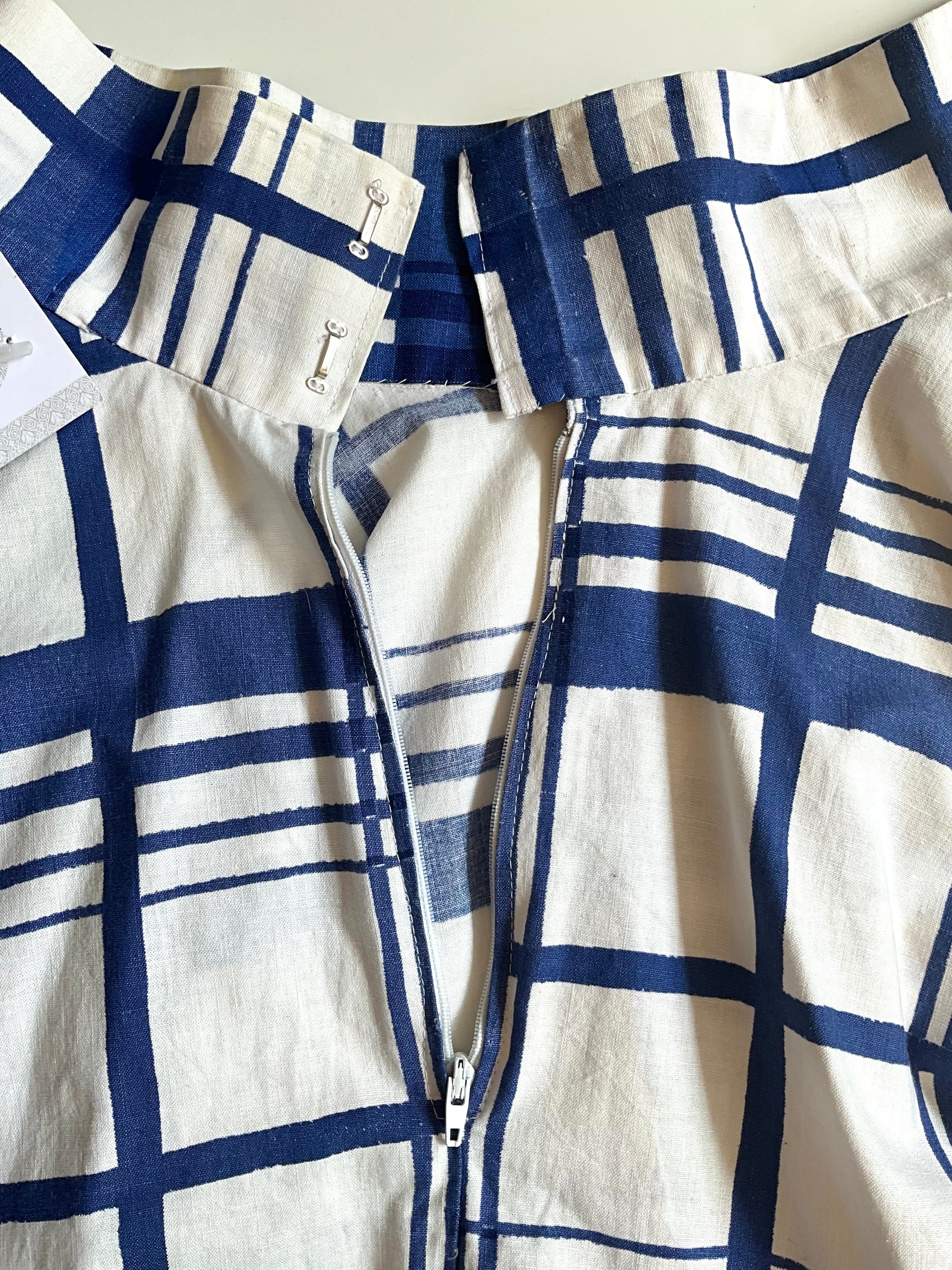 Close-up of a blue and white checkered shirt with a zipper