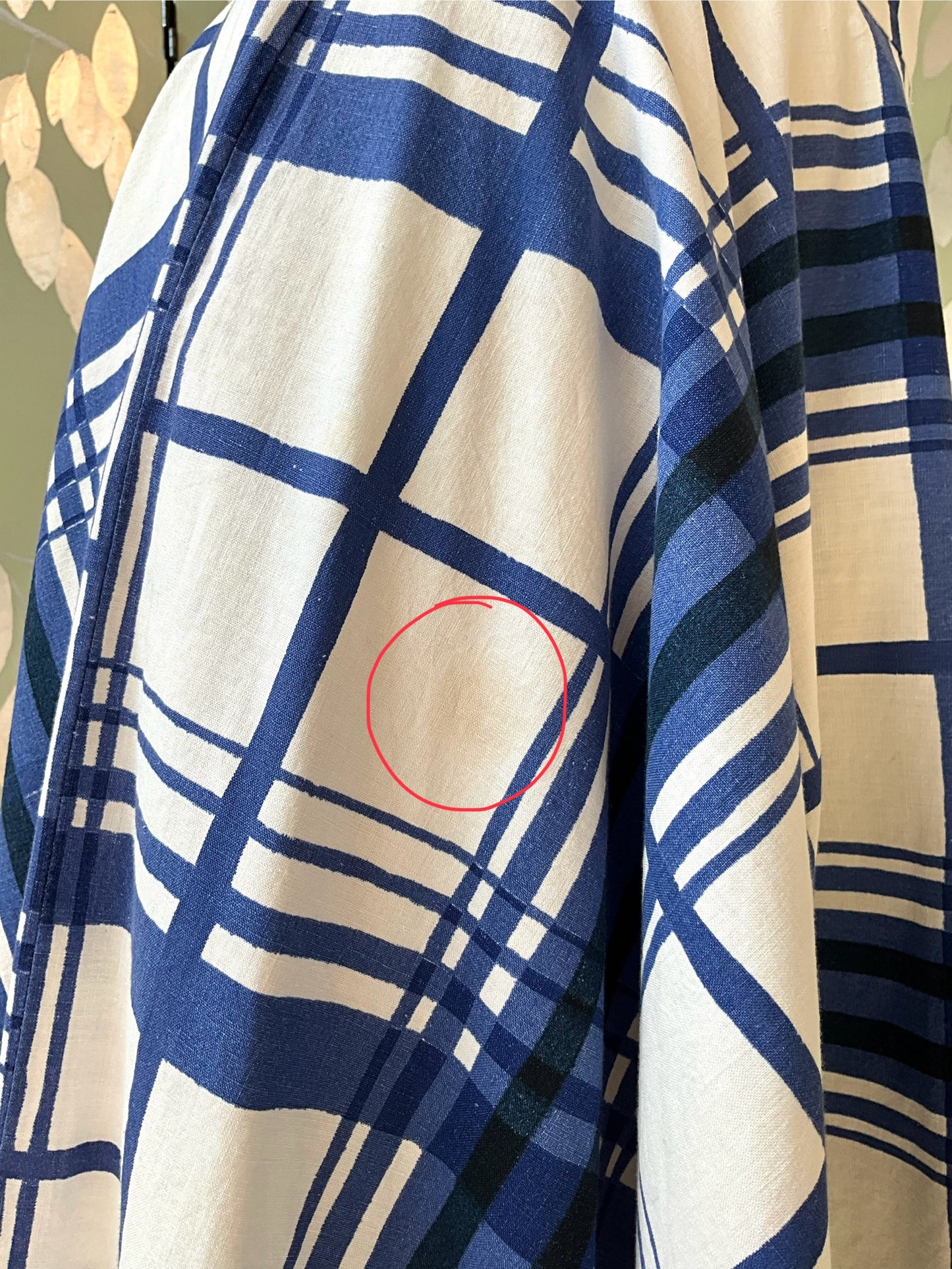 Blue and white checkered fabric with a red circle indicating a defect.