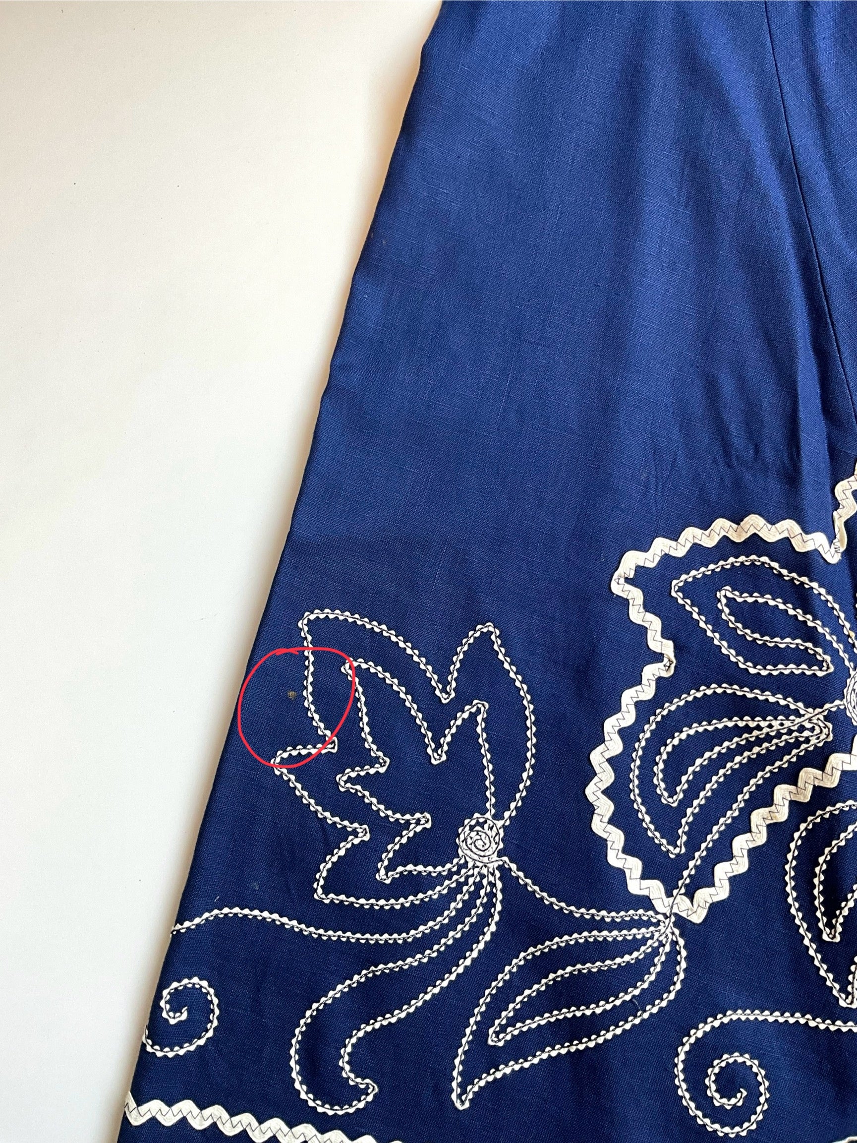 Blue fabric with white floral embroidery on a white background