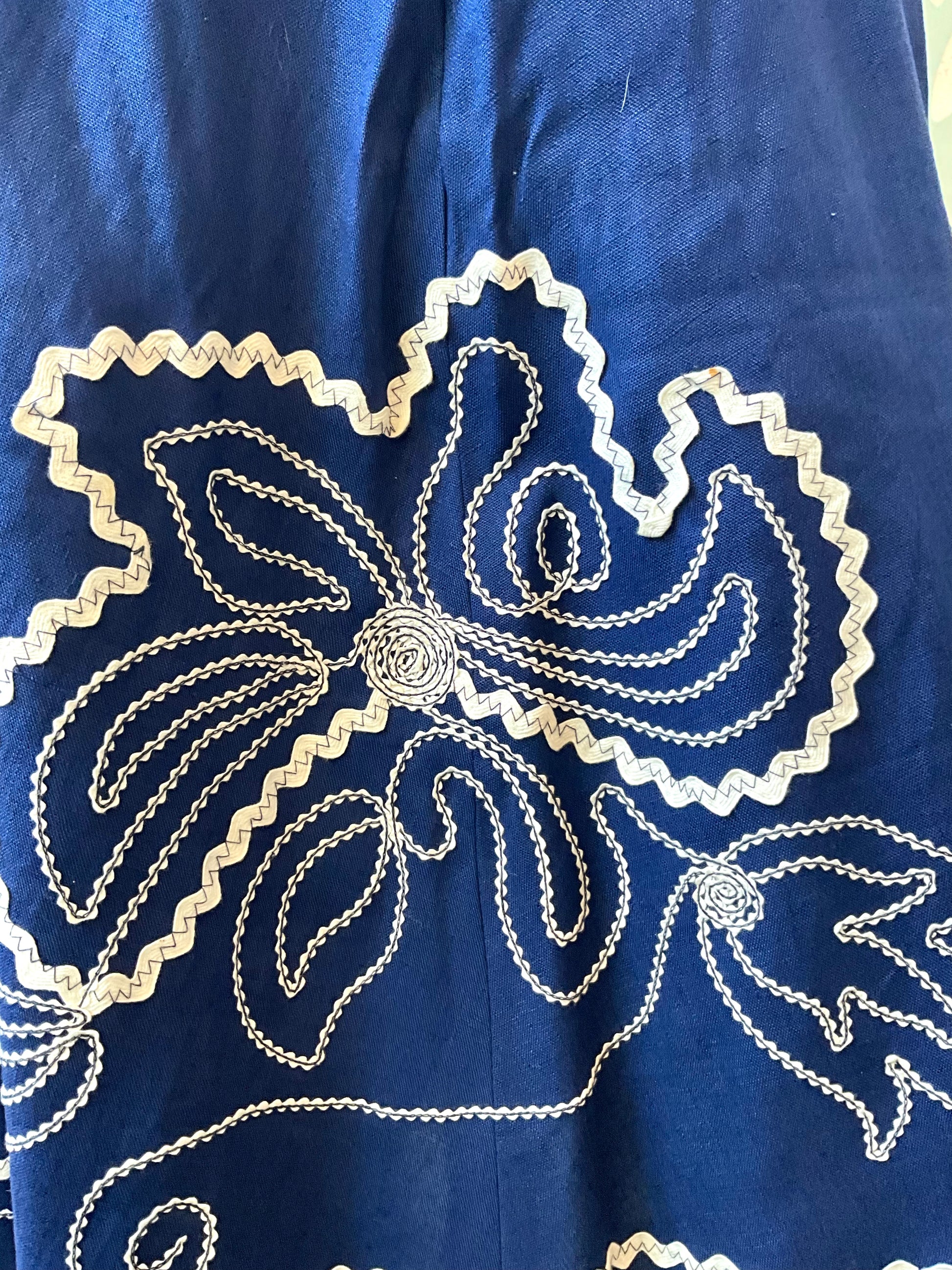 Close-up of a blue fabric with white floral embroidery