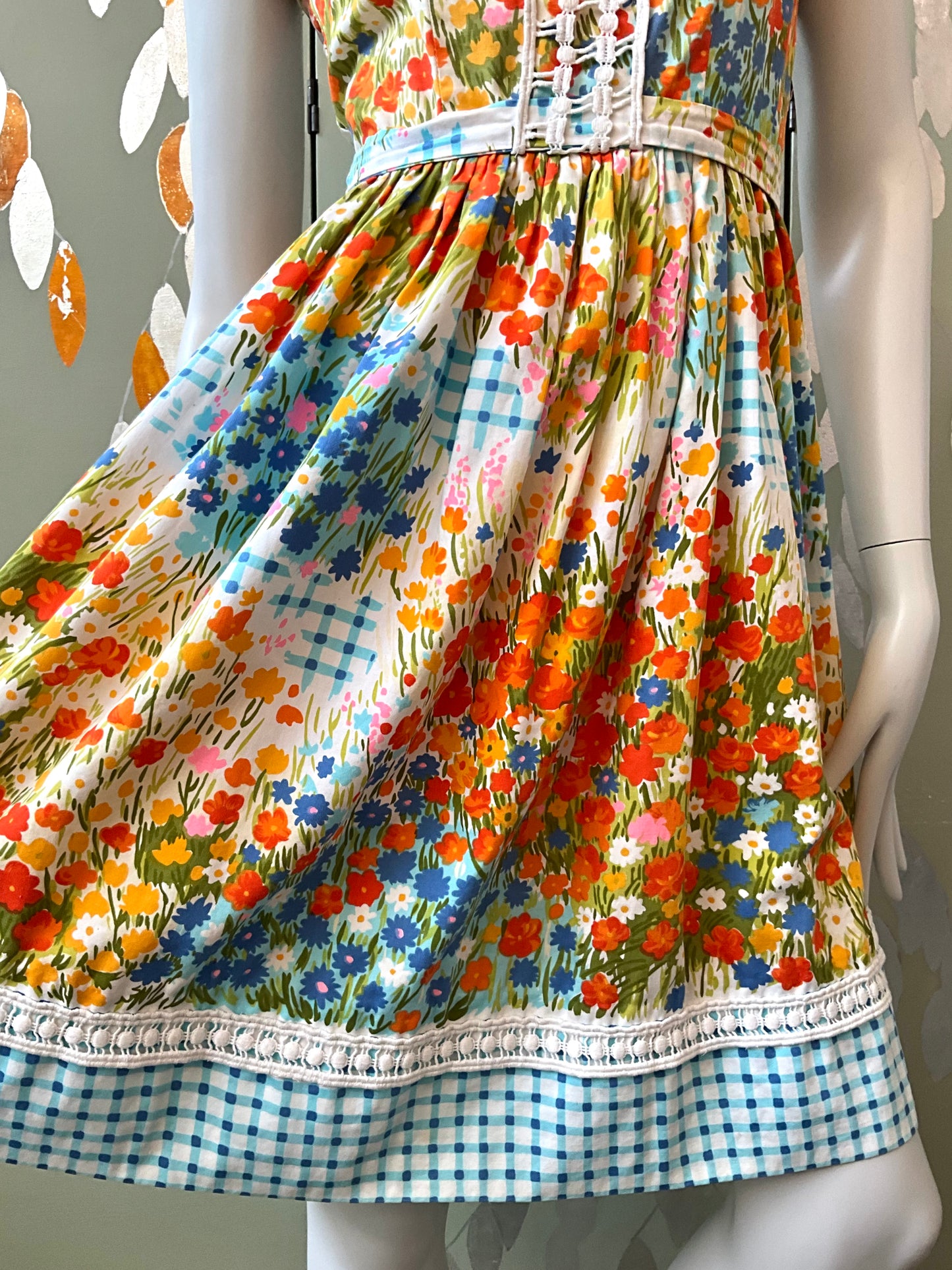 Colorful floral dress on a mannequin with a checkered bottom.