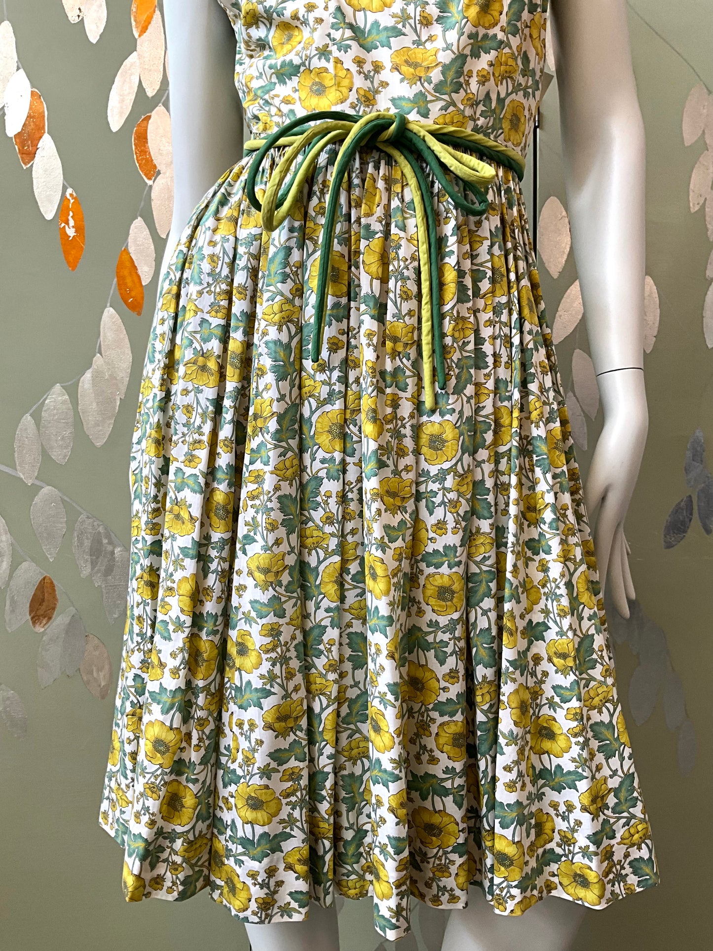 Floral dress on a mannequin with a decorative background