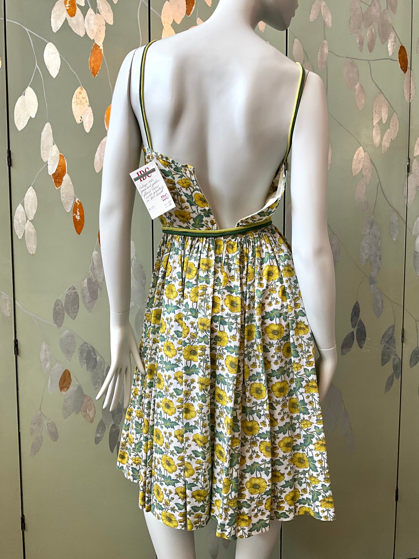 Floral dress on a mannequin with a patterned background