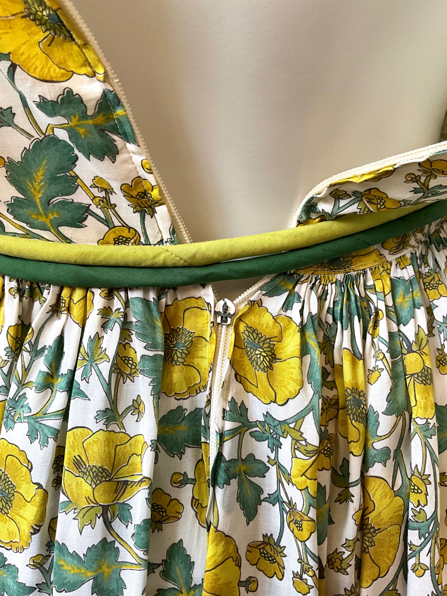 Floral dress with yellow flowers and green leaves on a white background