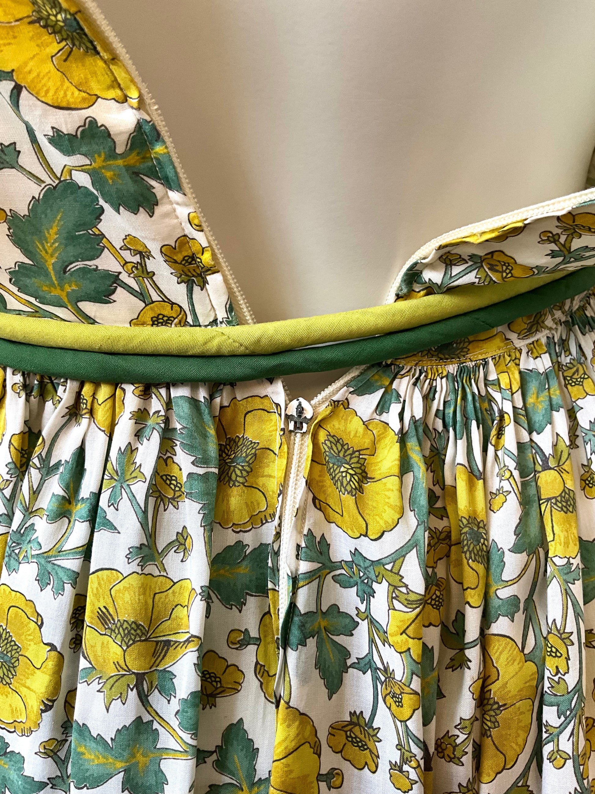 Floral dress with yellow flowers and green leaves on a white background