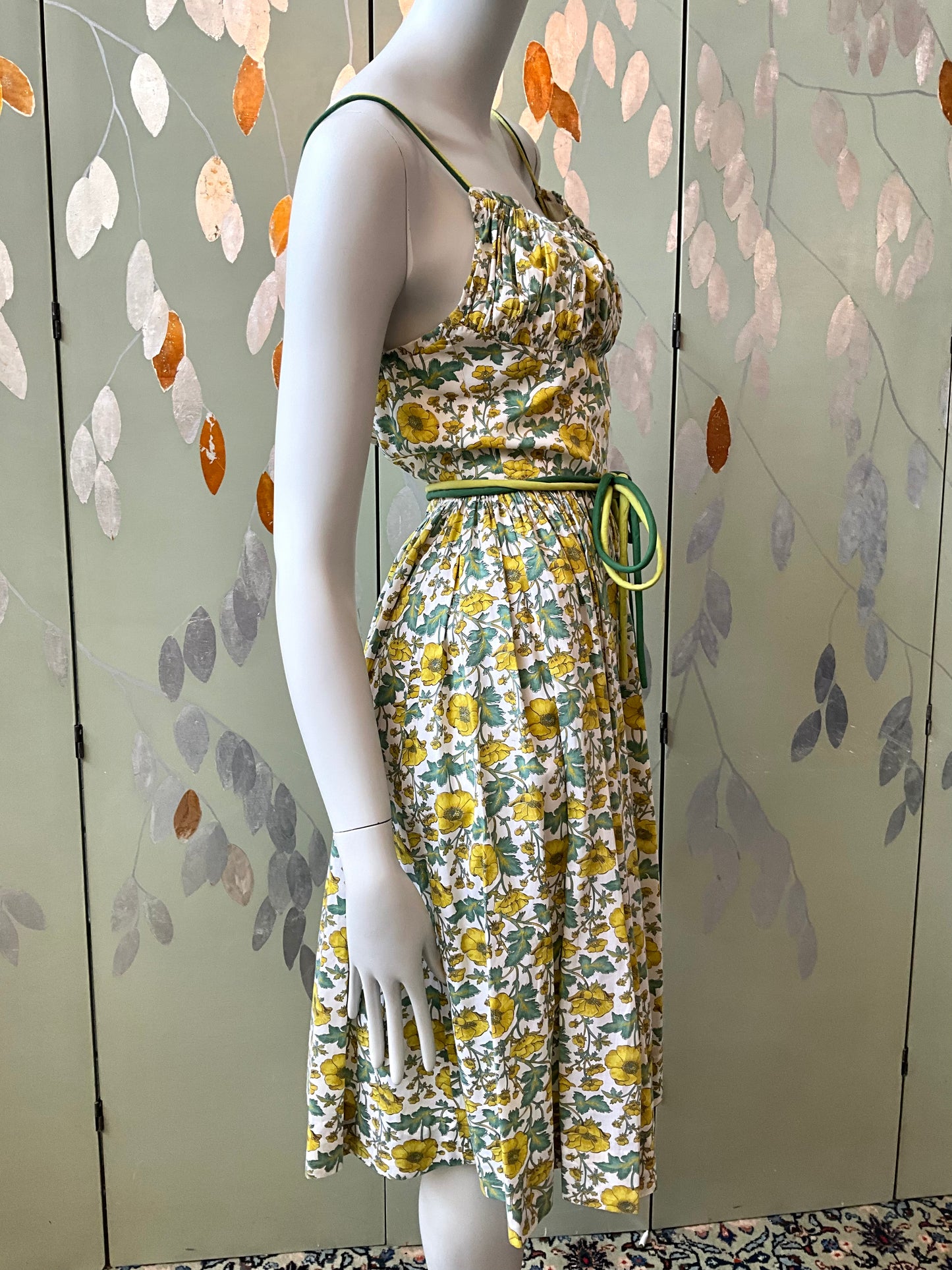 Mannequin wearing a floral dress with a decorative background