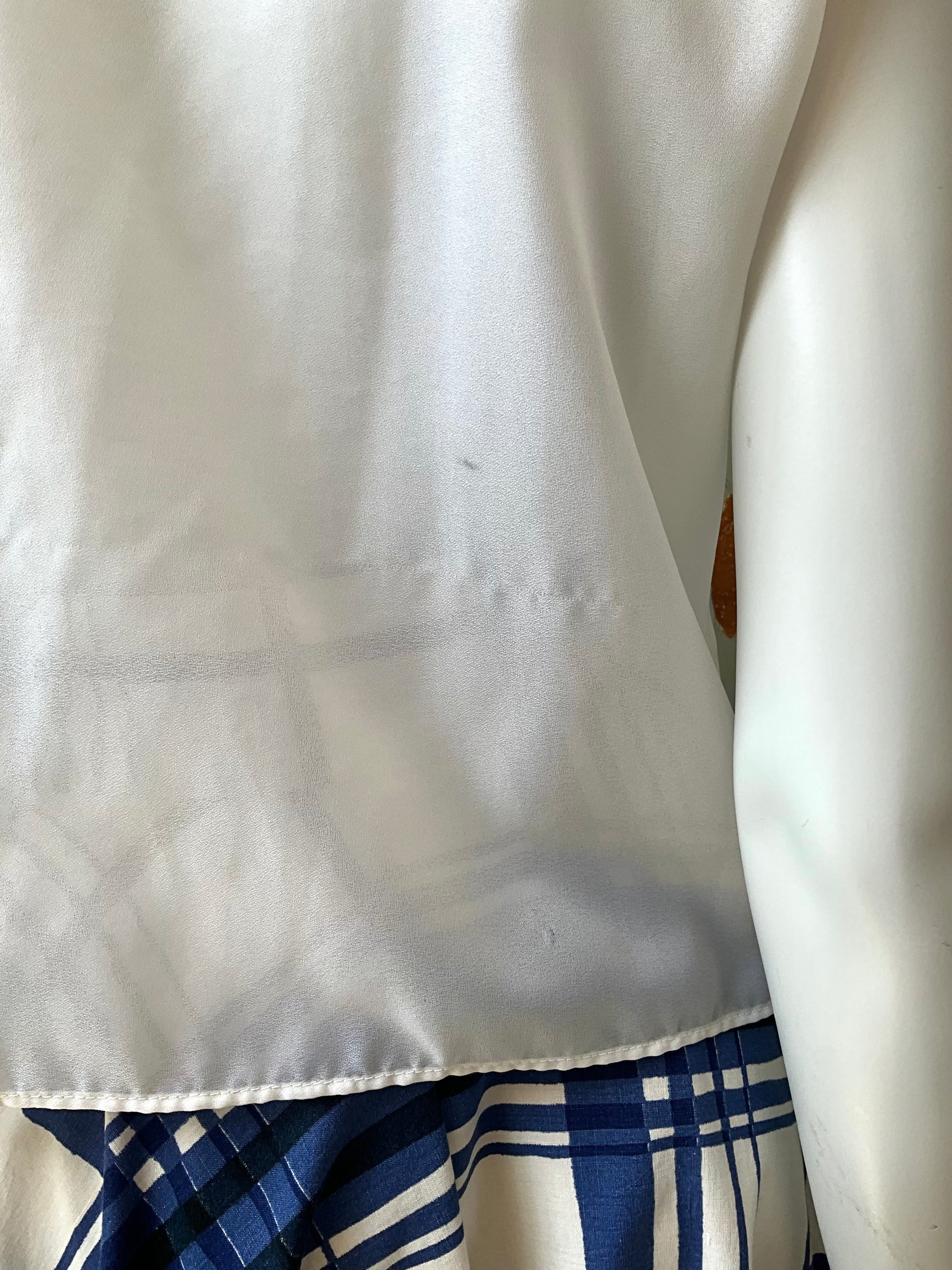 Back view of a white blouse on a mannequin 