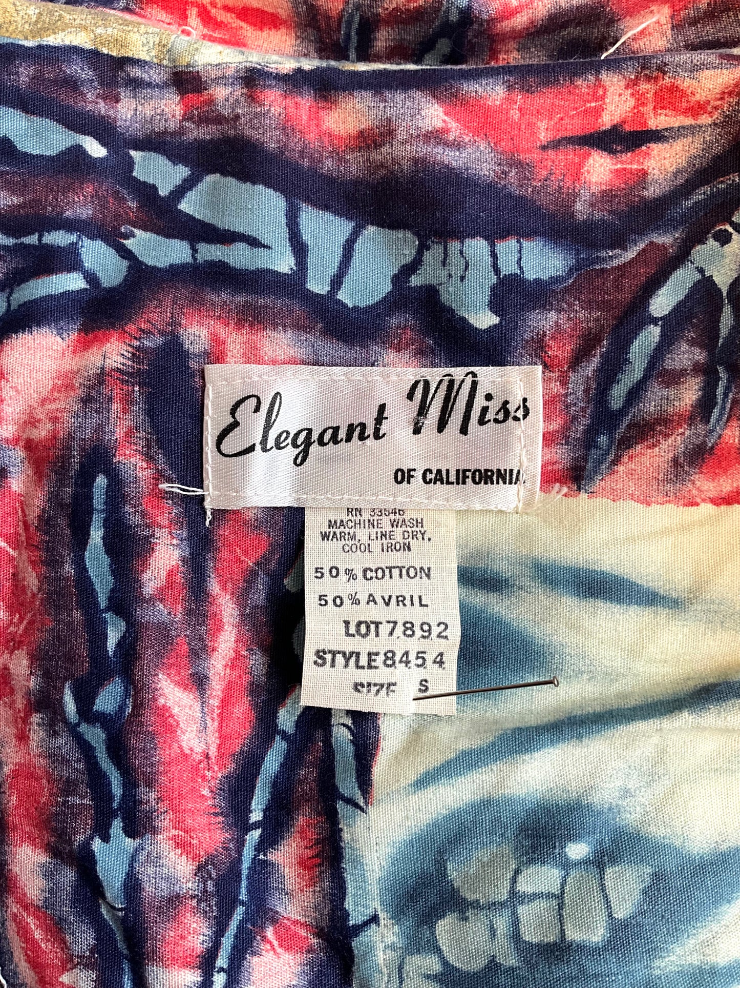 Fabric with 'Elegant Miss of California' label on patterned dress
