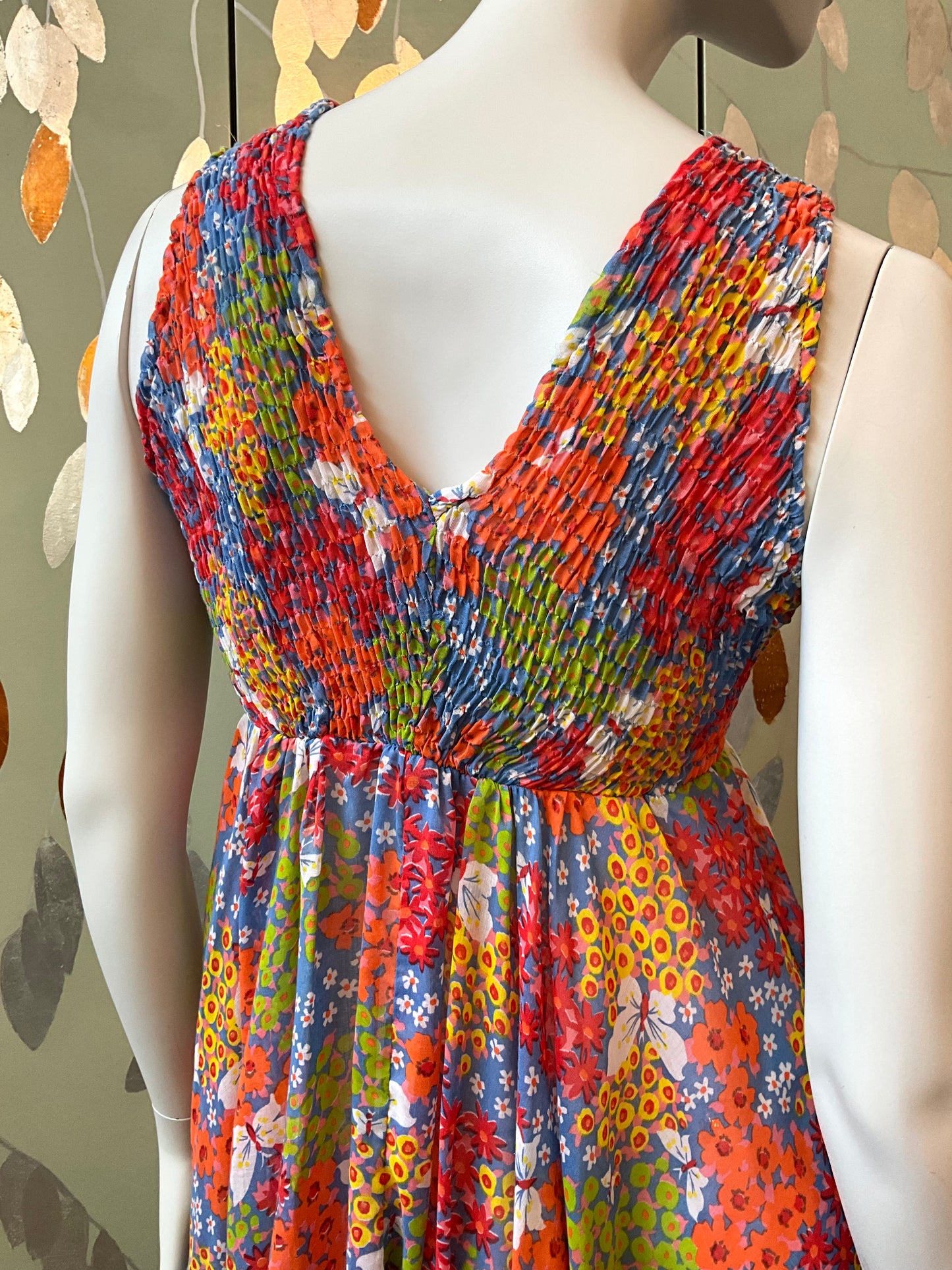 Colorful patterned dress on a mannequin against a neutral background