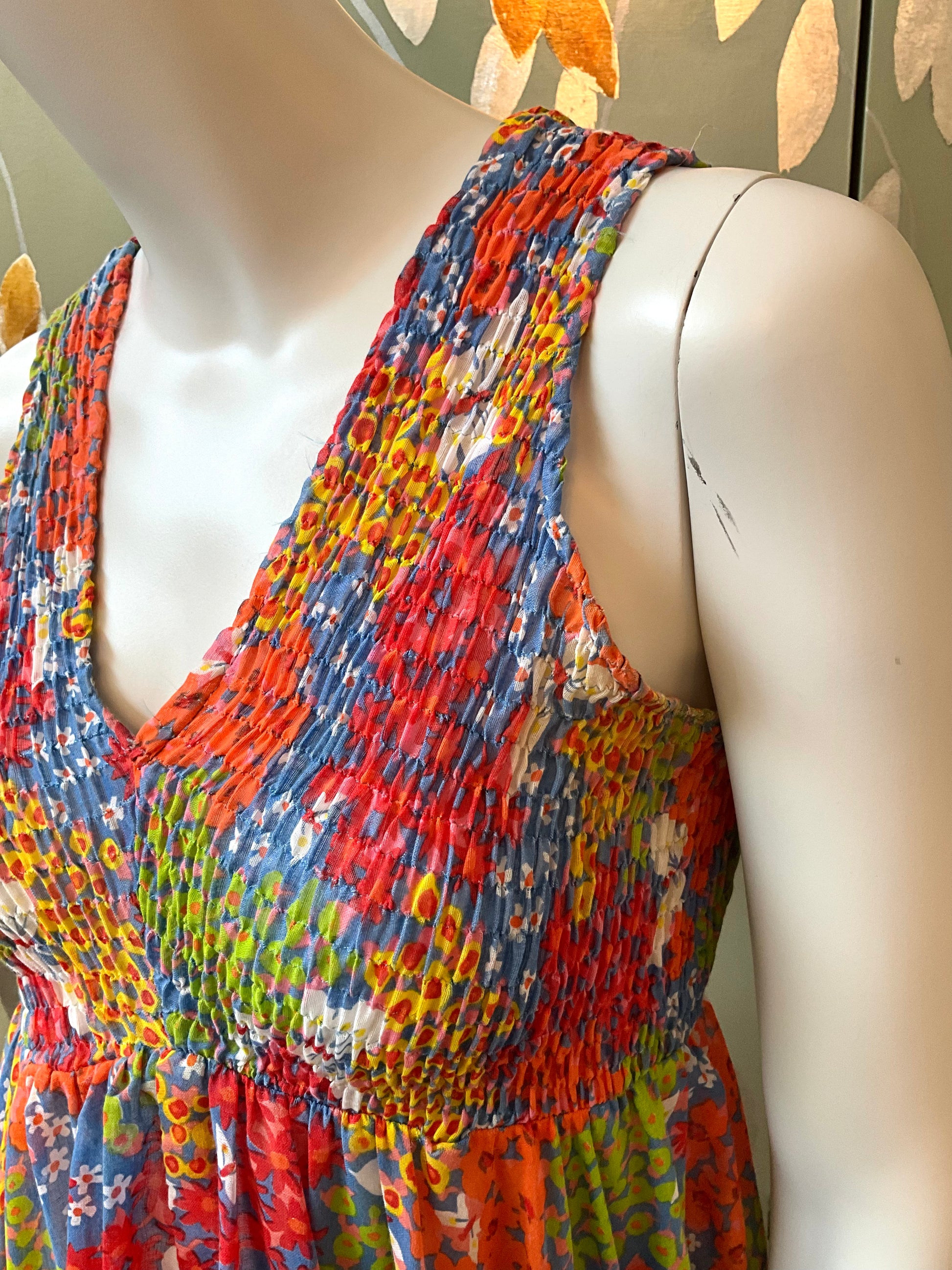 Colorful patterned dress on a mannequin against a neutral background