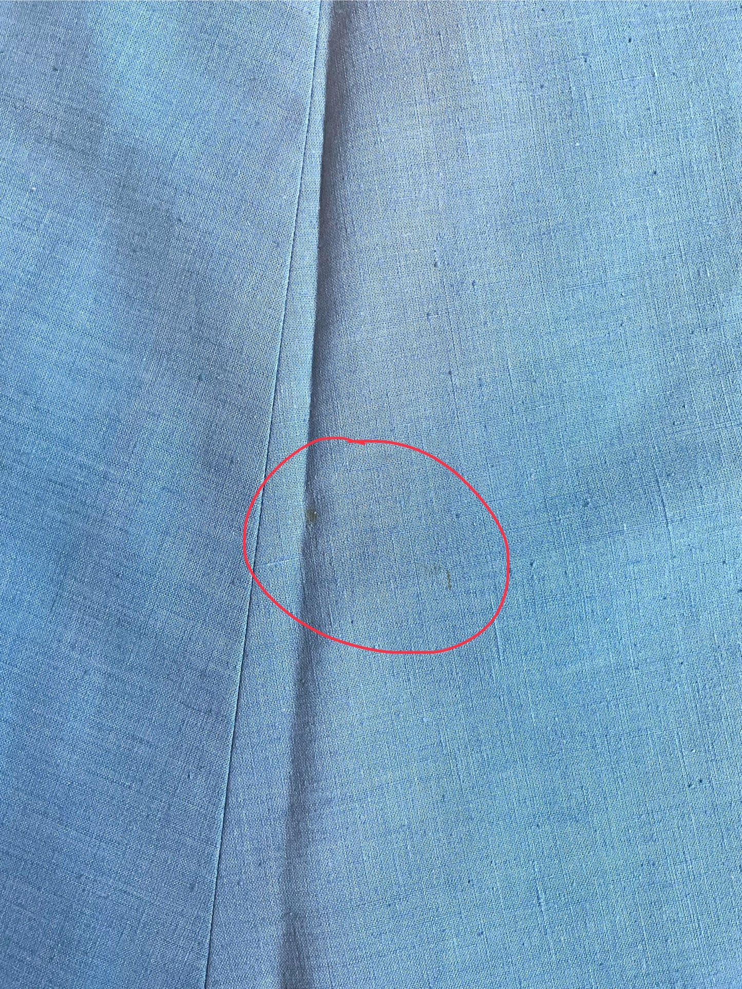 Close-up of blue fabric with a red circle highlighting a spot.