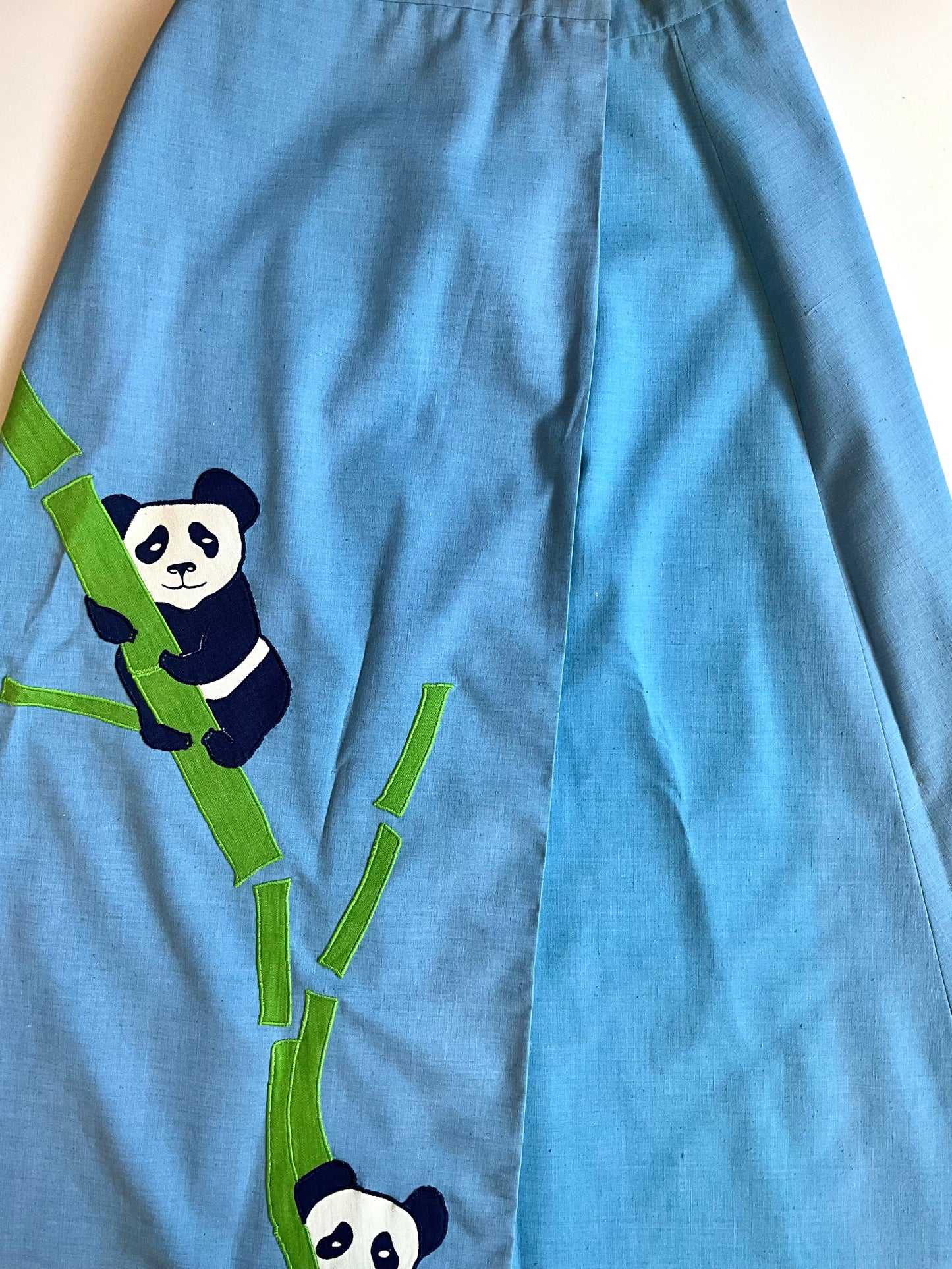 Blue fabric with panda and bamboo design on a white background