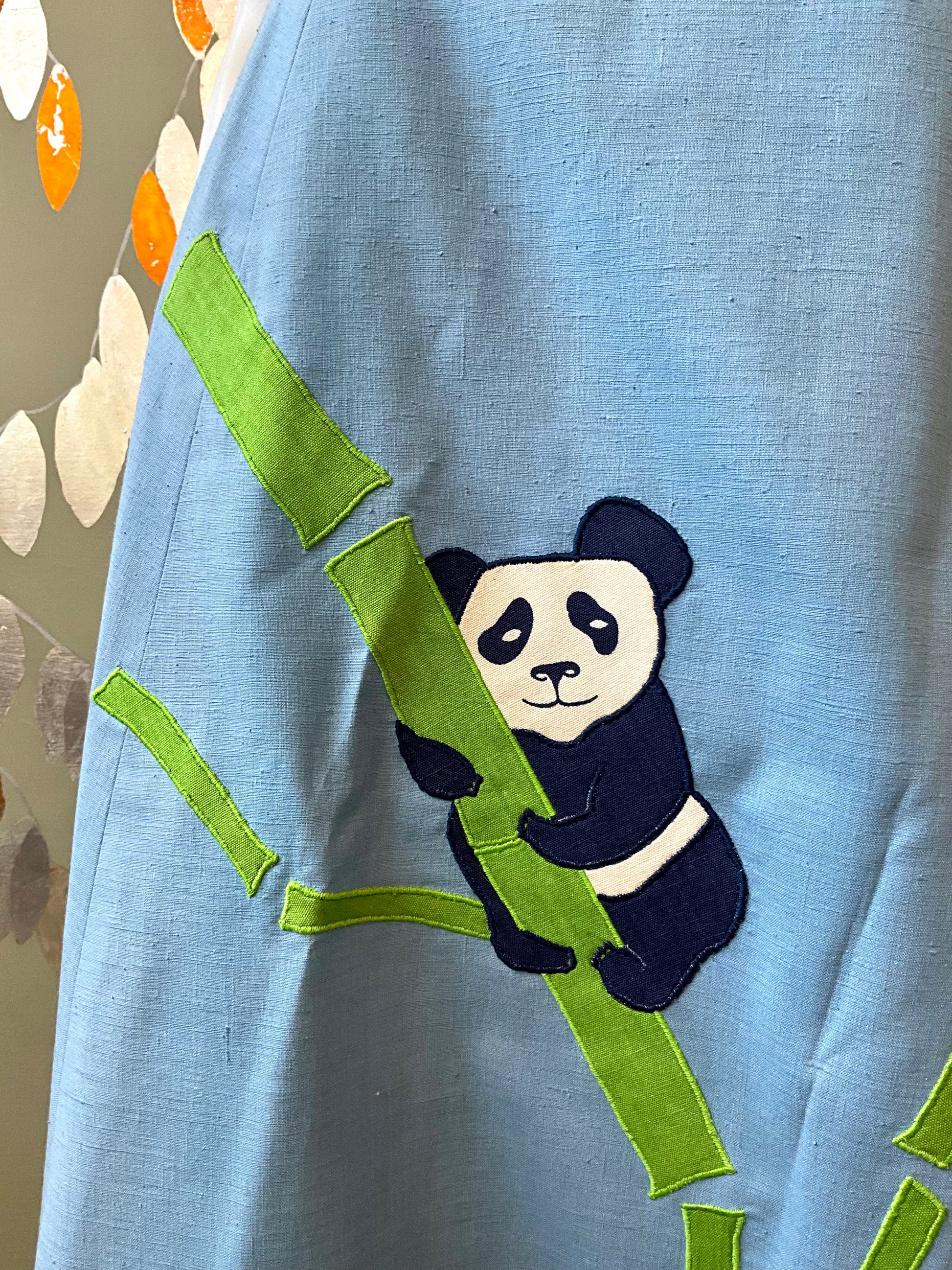 Panda bear and bamboo design on a blue fabric background