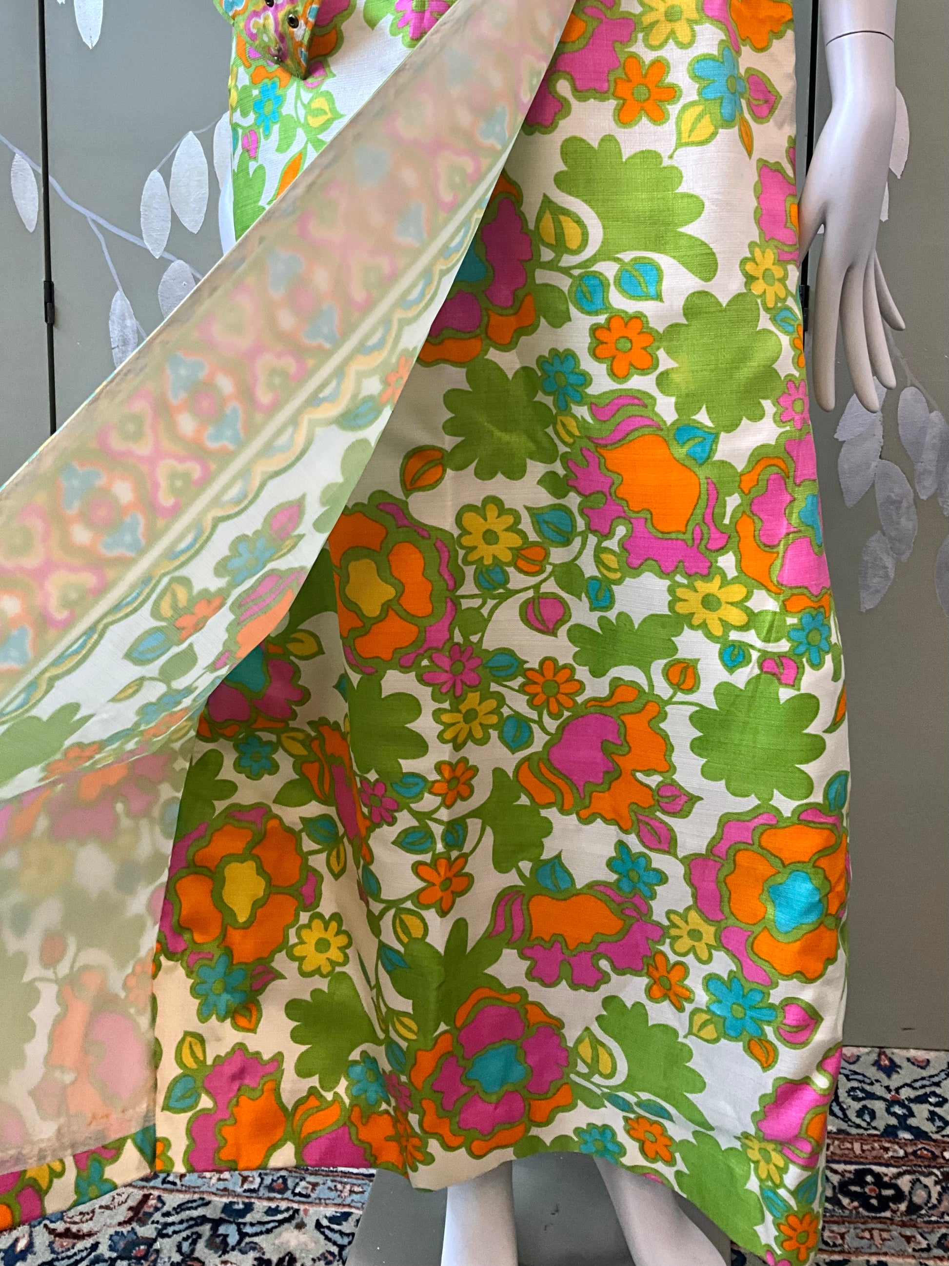 Mannequin wearing a colorful floral dress with a patterned fabric 