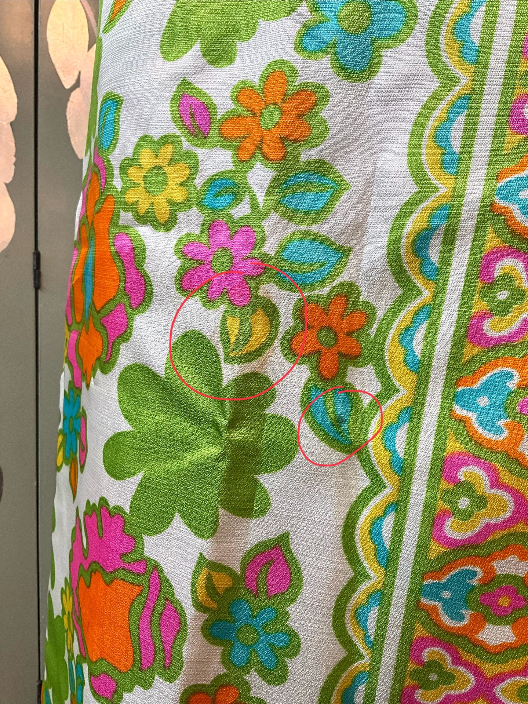Close-up of a colorful floral patterned fabric with green, orange, and blue colors.