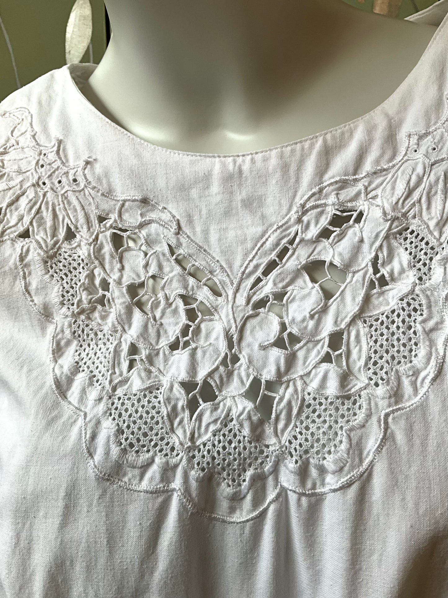 White dress with intricate lace detailing on a mannequin