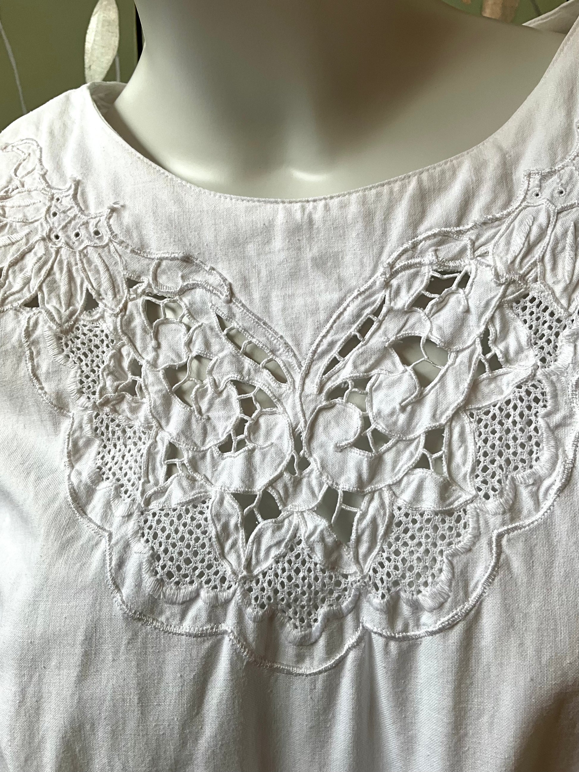 White dress with intricate lace detailing on a mannequin
