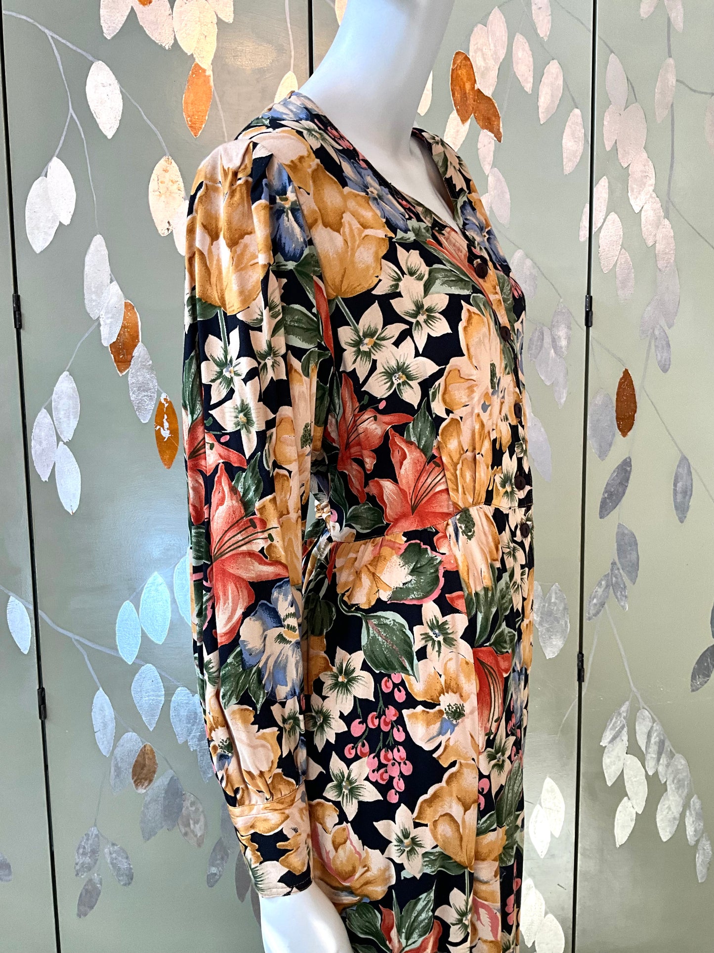 Mannequin wearing a floral dress with a decorative background