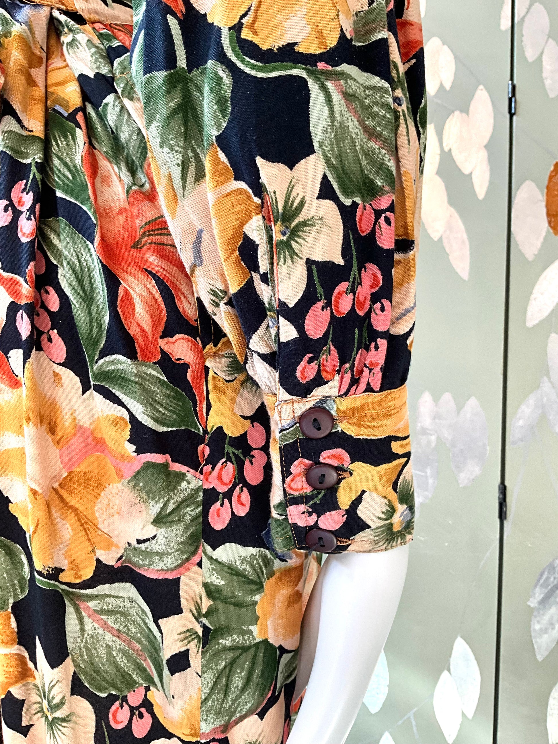 close up of buttoned cuffs on a floral patterned dress with a neutral background
