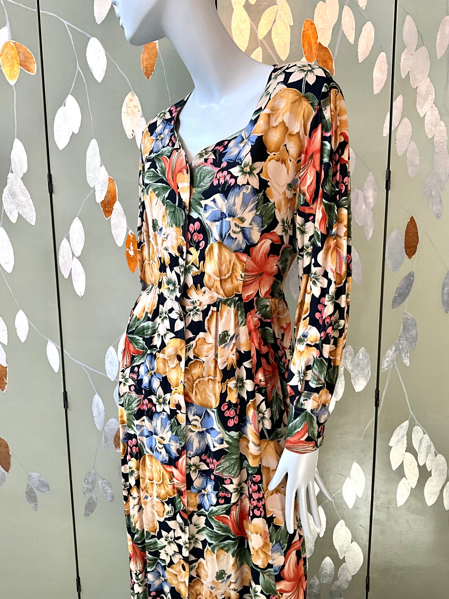 Mannequin wearing a floral dress with a decorative background