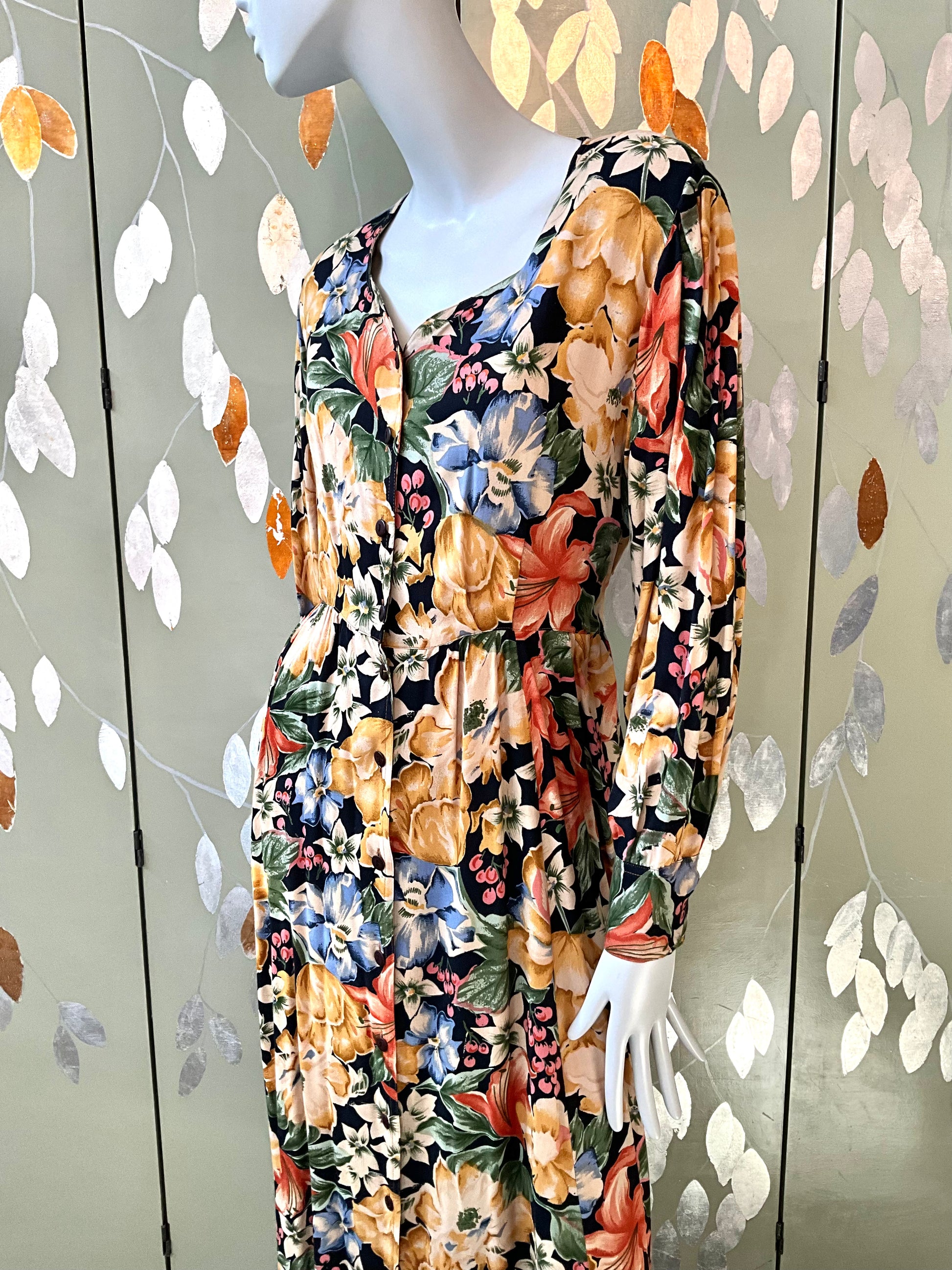 Mannequin wearing a floral dress with a decorative background