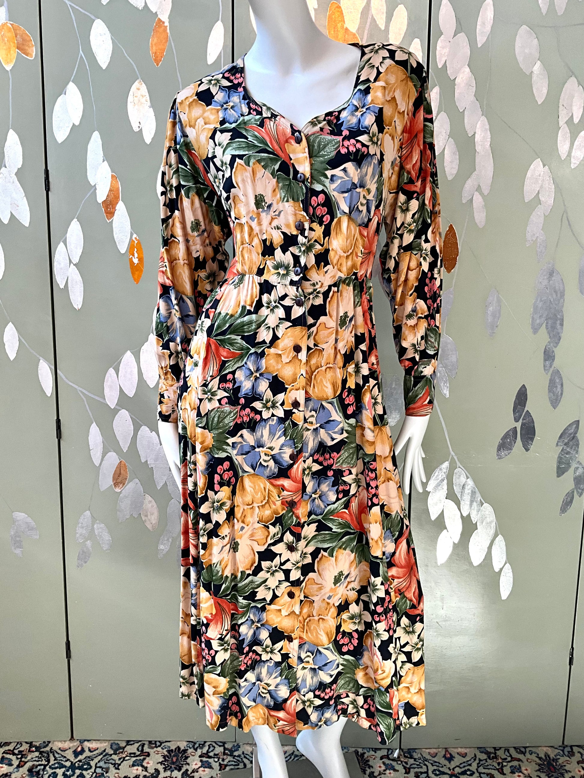 Mannequin wearing a floral dress with a decorative background