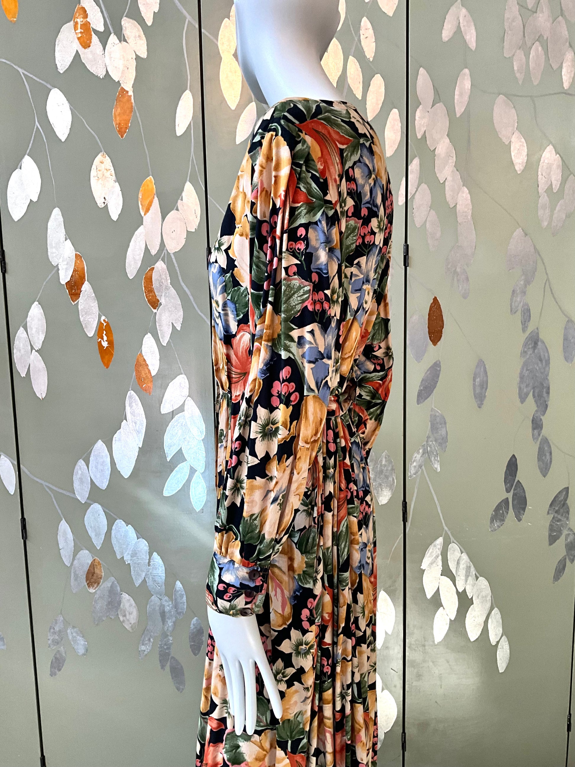 Mannequin wearing a floral dress with a decorative leafy background