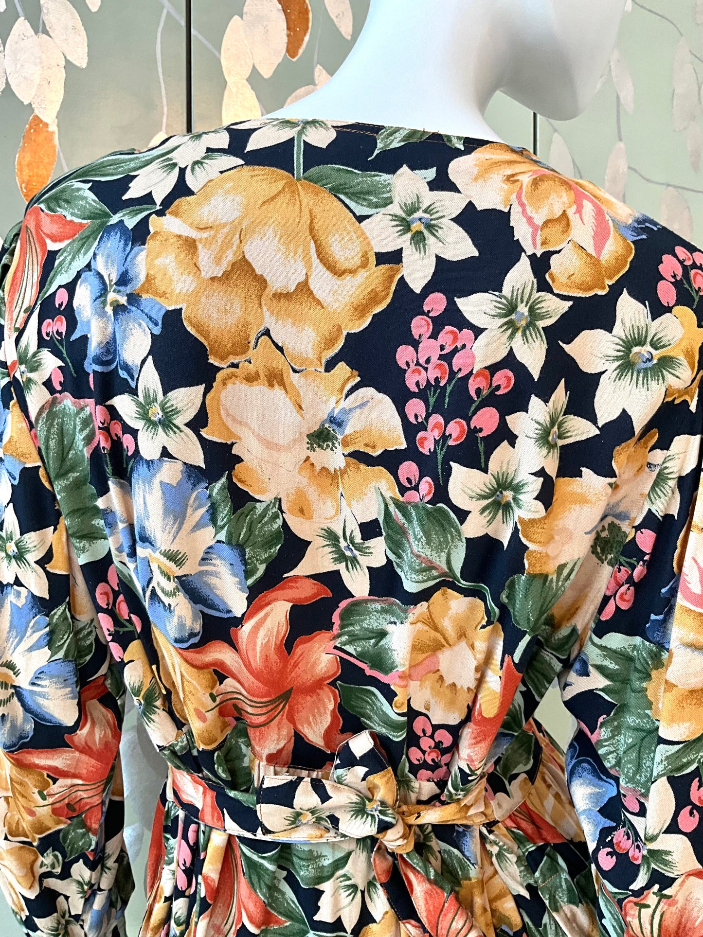 Floral patterned dress on a mannequin against a green background